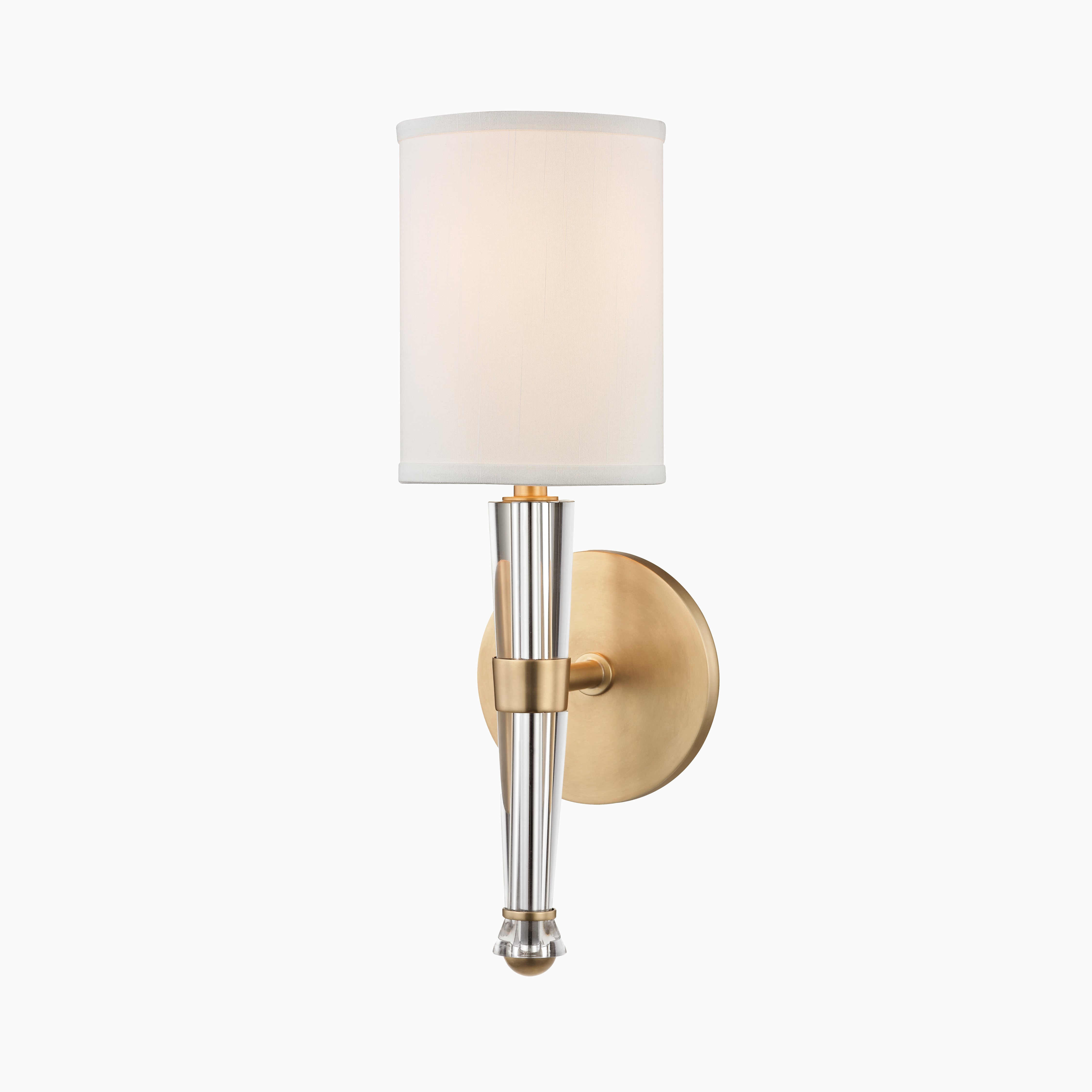 Wall sconce with aged brass backplate, tapered silver-toned body, and white silk cylindrical shade for soft, ambient lighting.