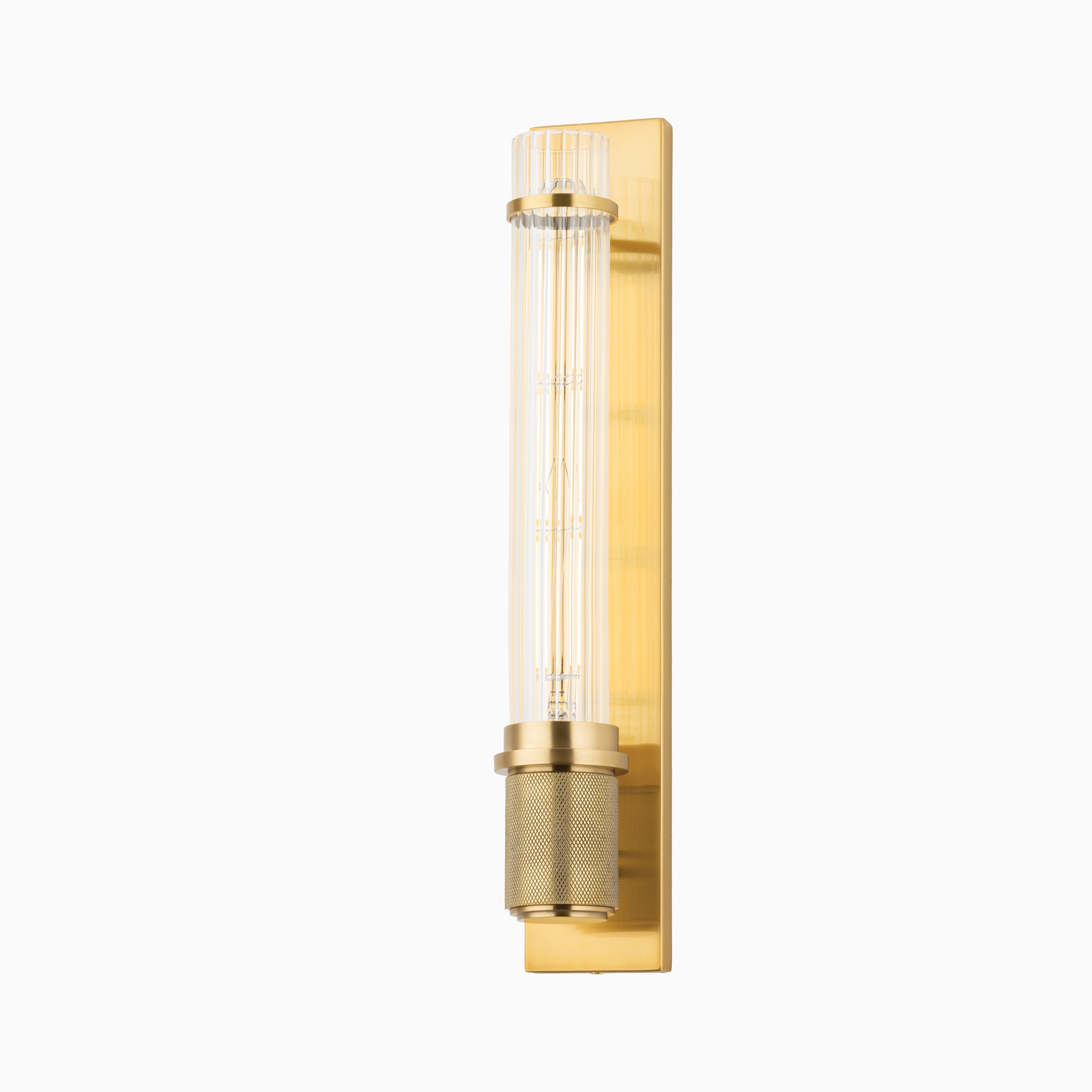 With a slim fluted shade and metallic mesh detail, Tyson Wall Sconce in Aged Brass casts soft ambient light while bringing height and golden warmth to modern spaces.