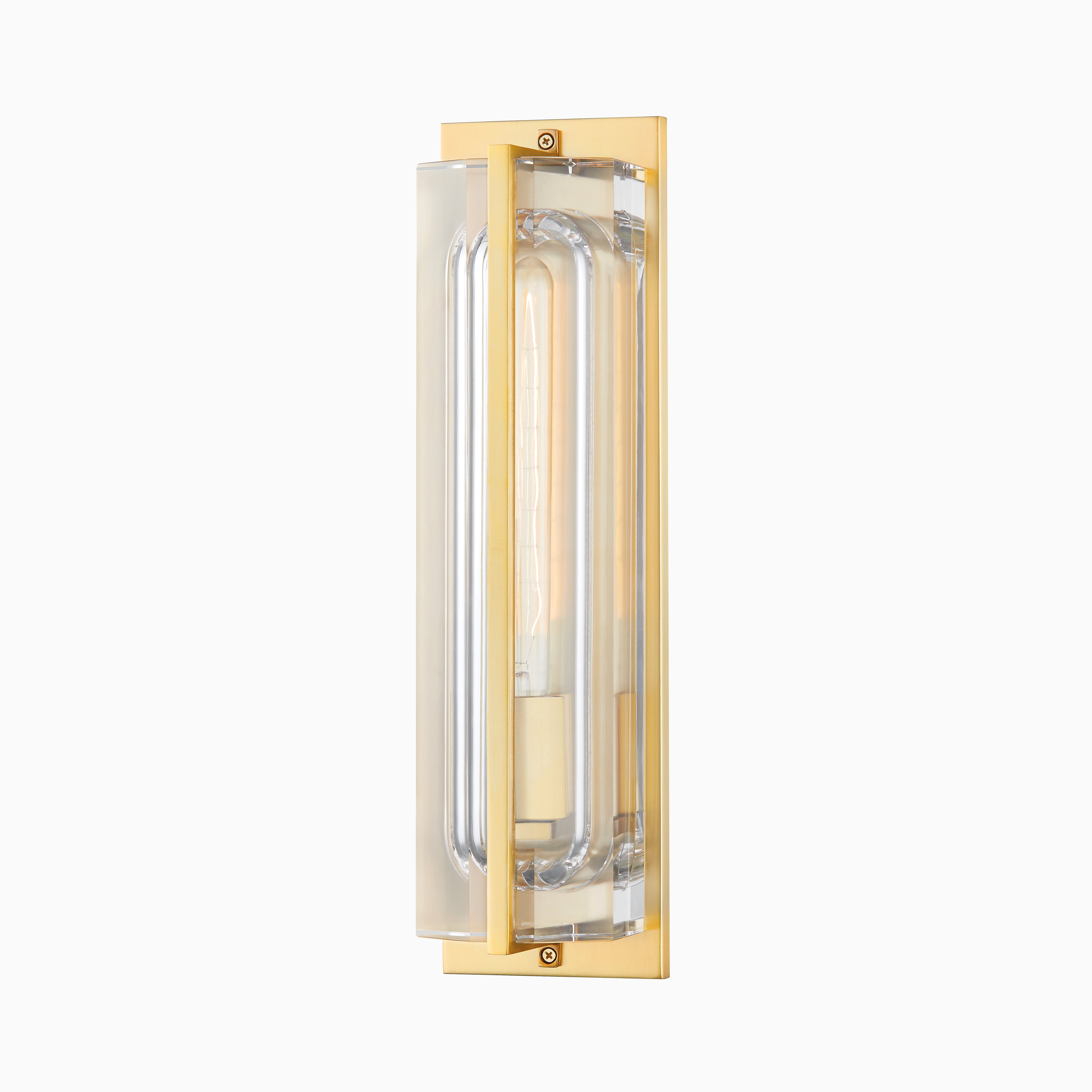 Slim wall sconce with clear glass tubing framed in aged brass for a sleek, modern glow.