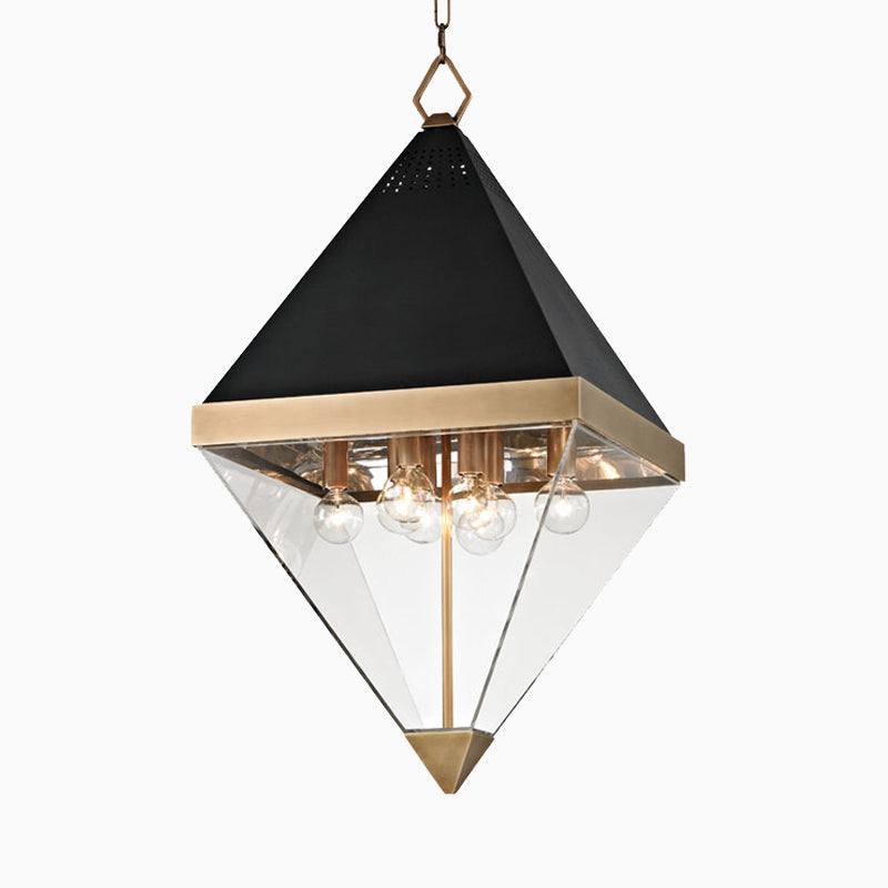 Geometric lantern in aged brass with a black pyramid top, clear glass panels, and exposed bulbs, suspended for a bold modern look.