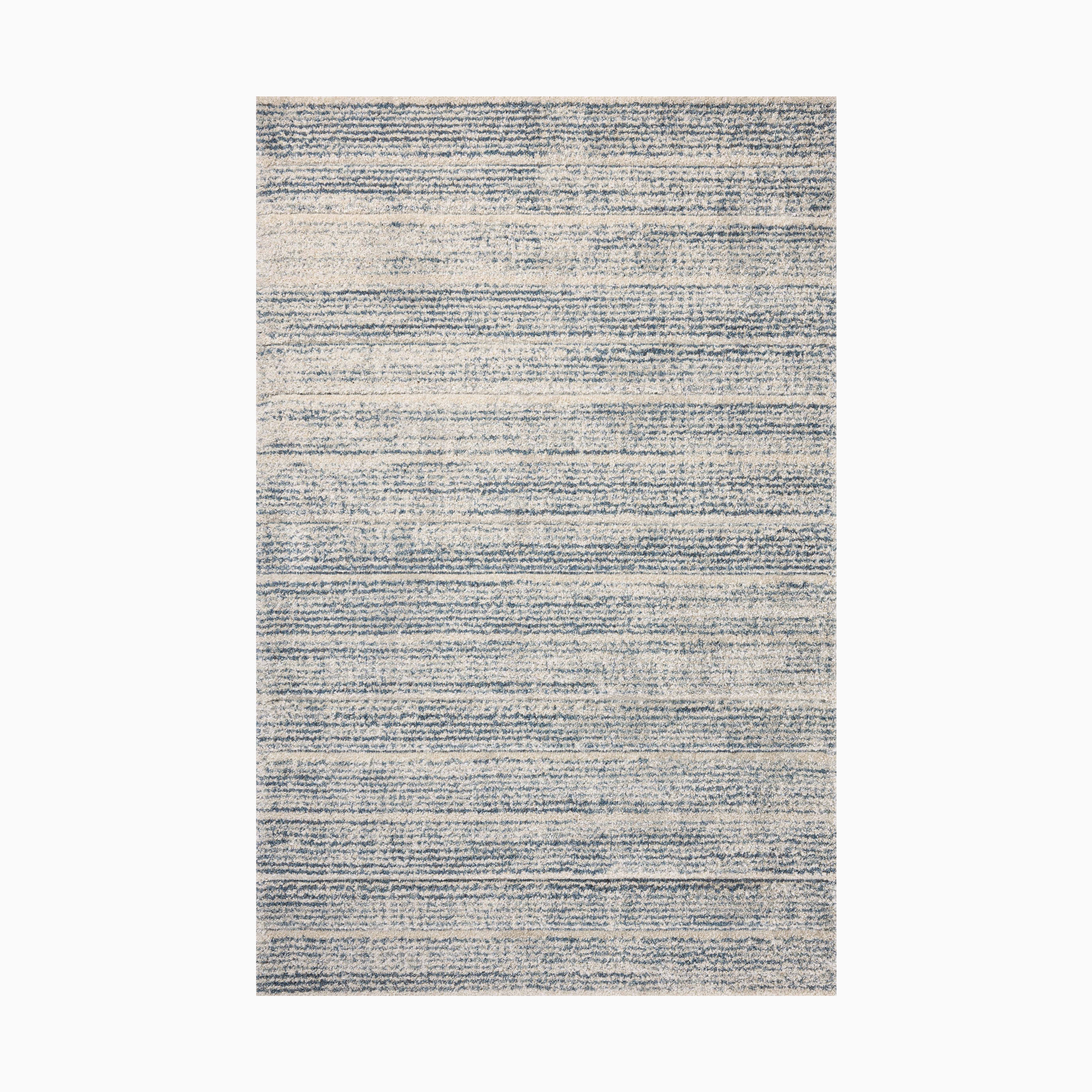 Power loomed area rug from Egypt made of polypropylene with a soft linear pattern in muted blue and ivory tones.