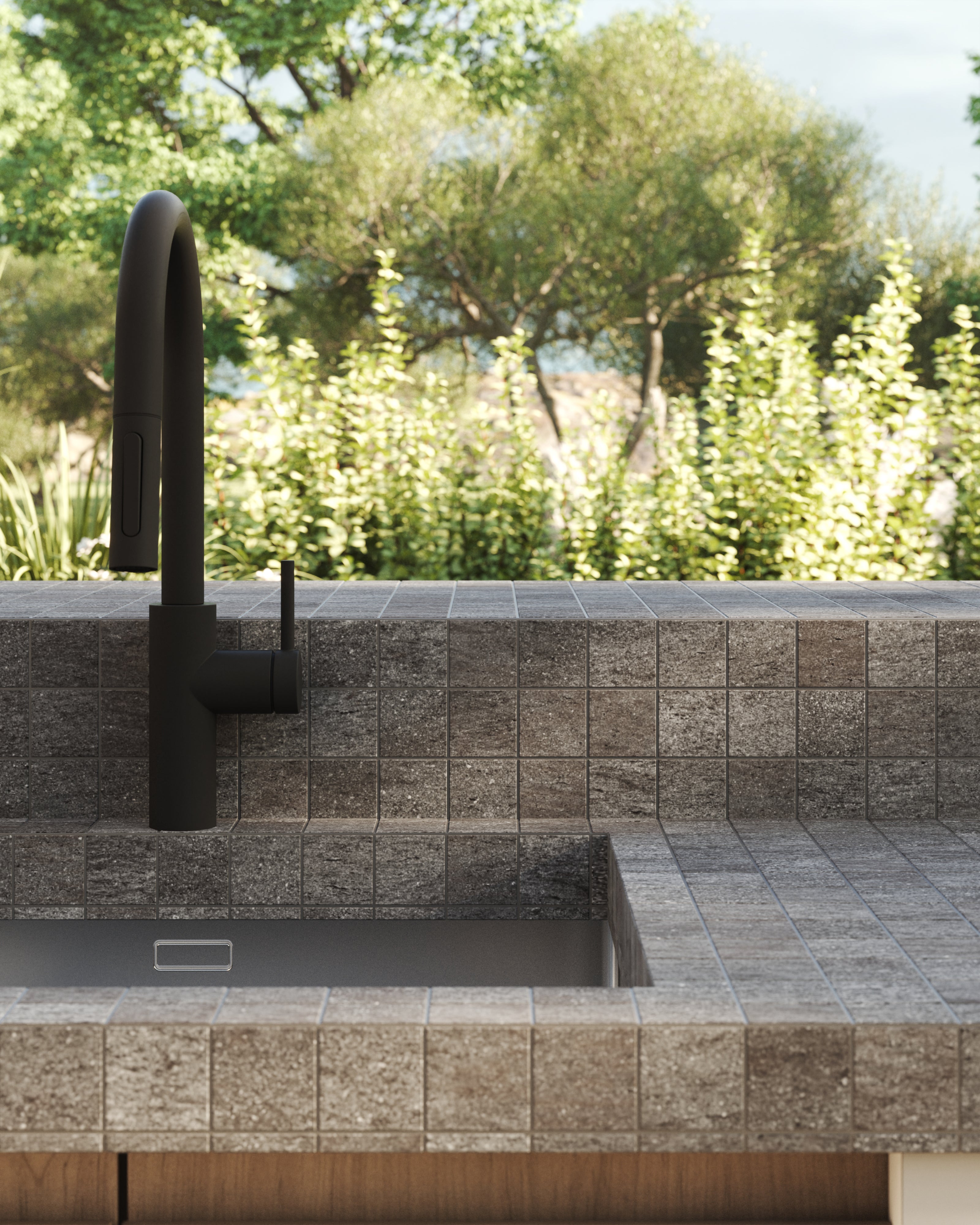 Modern outdoor kitchen sink with dark gray mosaic tile countertop and backsplash, complemented by a matte black faucet.