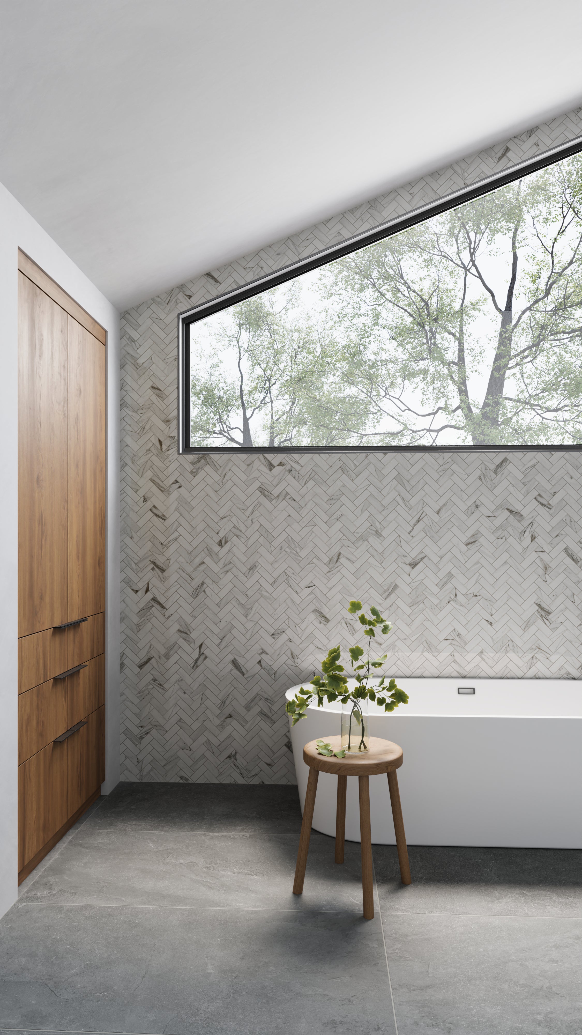 Minimalist bathroom featuring polished herringbone mosaic wall tiles, charcoal-toned flooring, and natural wood cabinetry, accented by a wooden stool with fresh greenery.