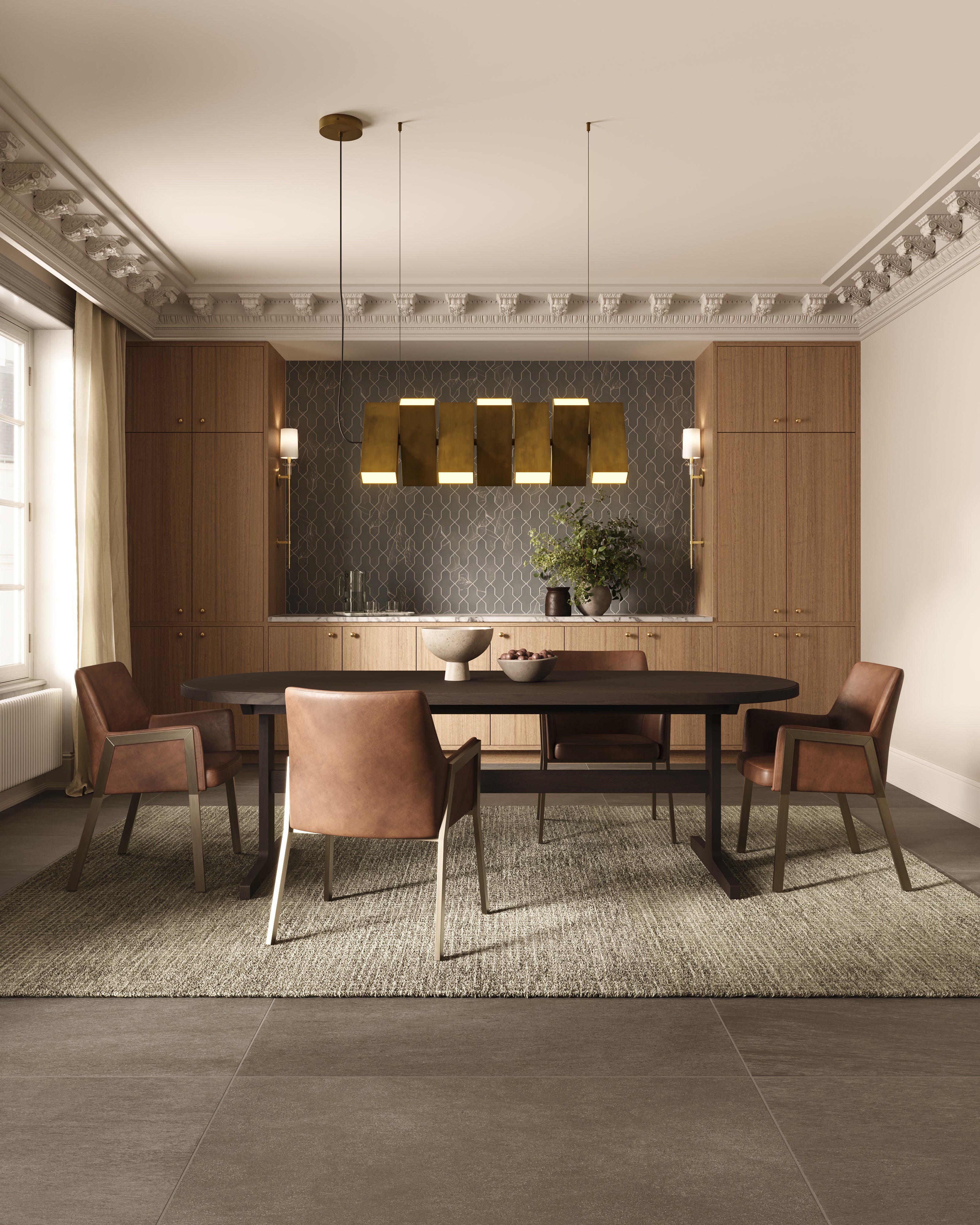 Warm brass pendants hang above an oval dining table in a dark wood finish, styled with leather chairs and layered textures that create a balanced, modern dining environment.