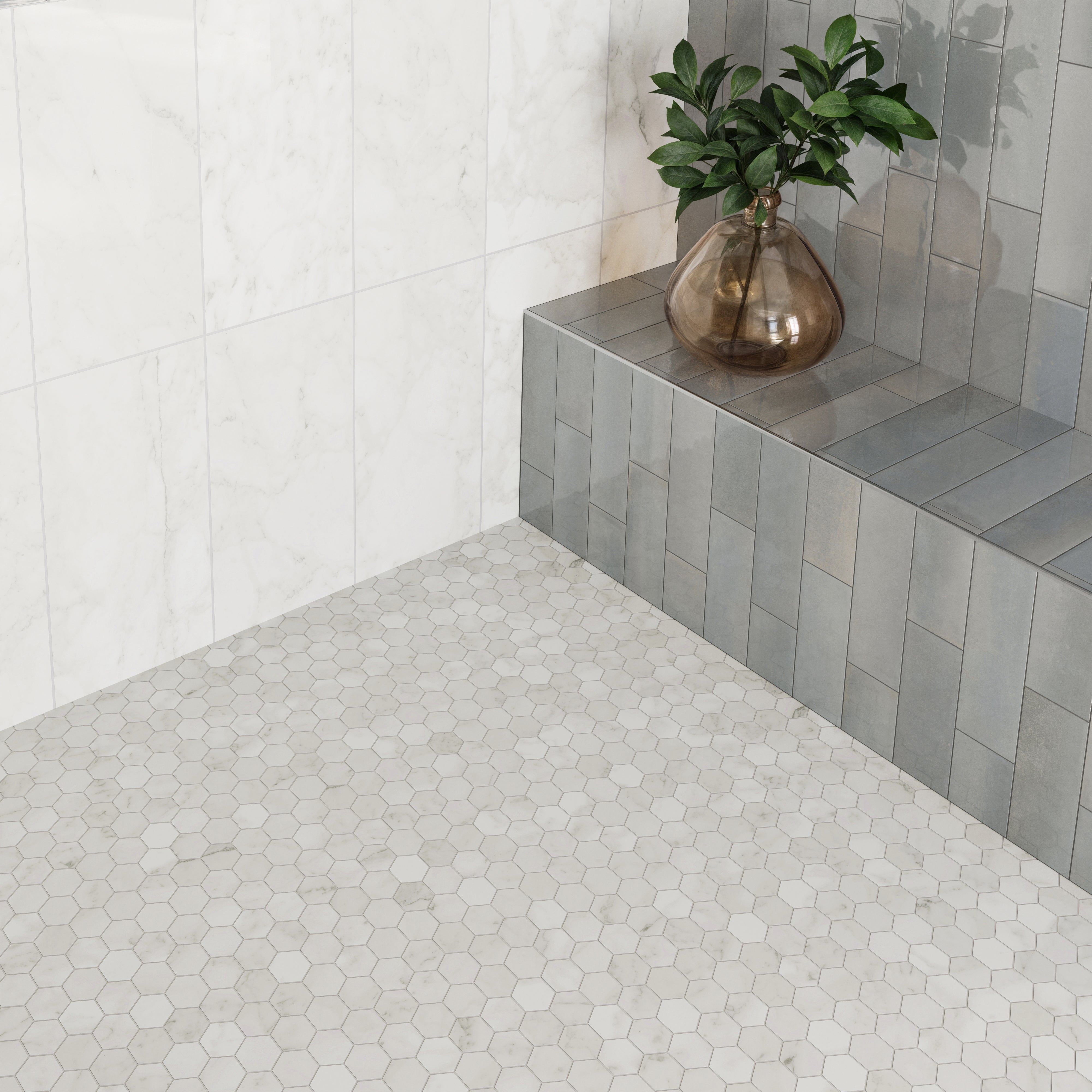 Stylish bathroom design featuring matte Carrara Bianco hexagon mosaic floor tiles, glossy marble look walls, and a sleek gray tiled bench with a decorative vase.