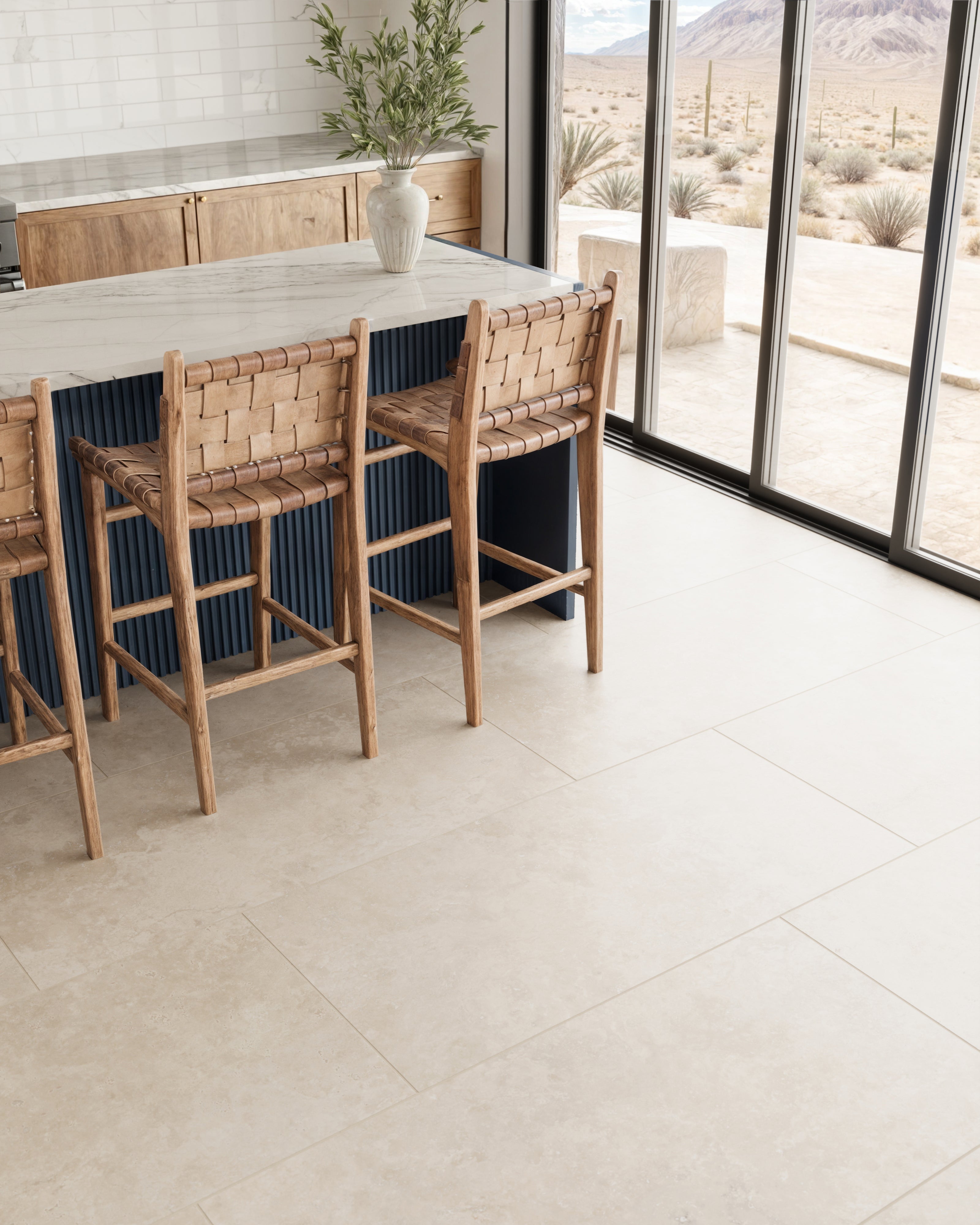Leona Marfil tile, 24x48 matte finish, set in a modern kitchen with woven bar stools and large glass doors showcasing a serene desert view.