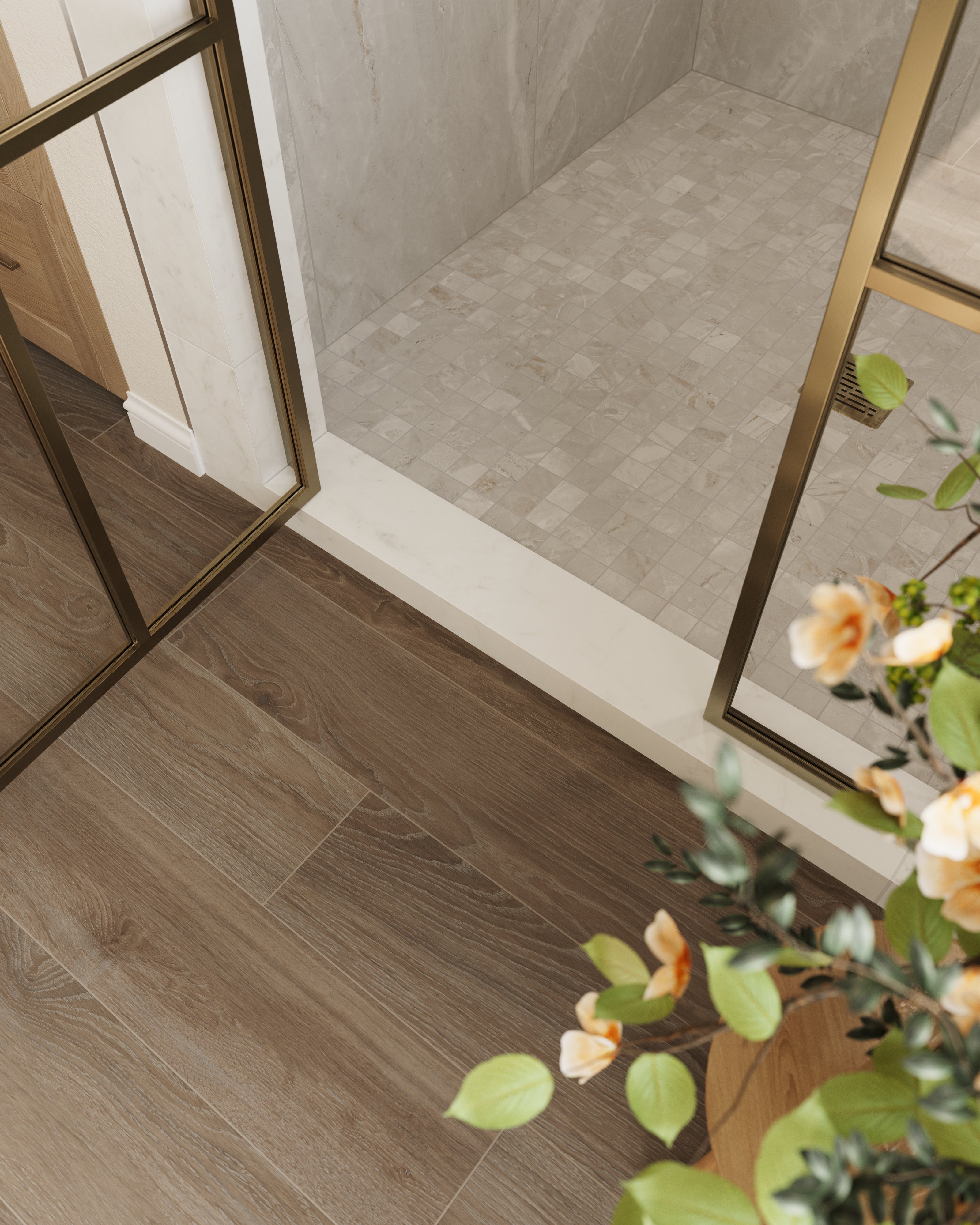 Elegant bathroom corner featuring beige mosaic marble look shower tiles, wood-look flooring, and a gold-framed glass door for a refined touch.