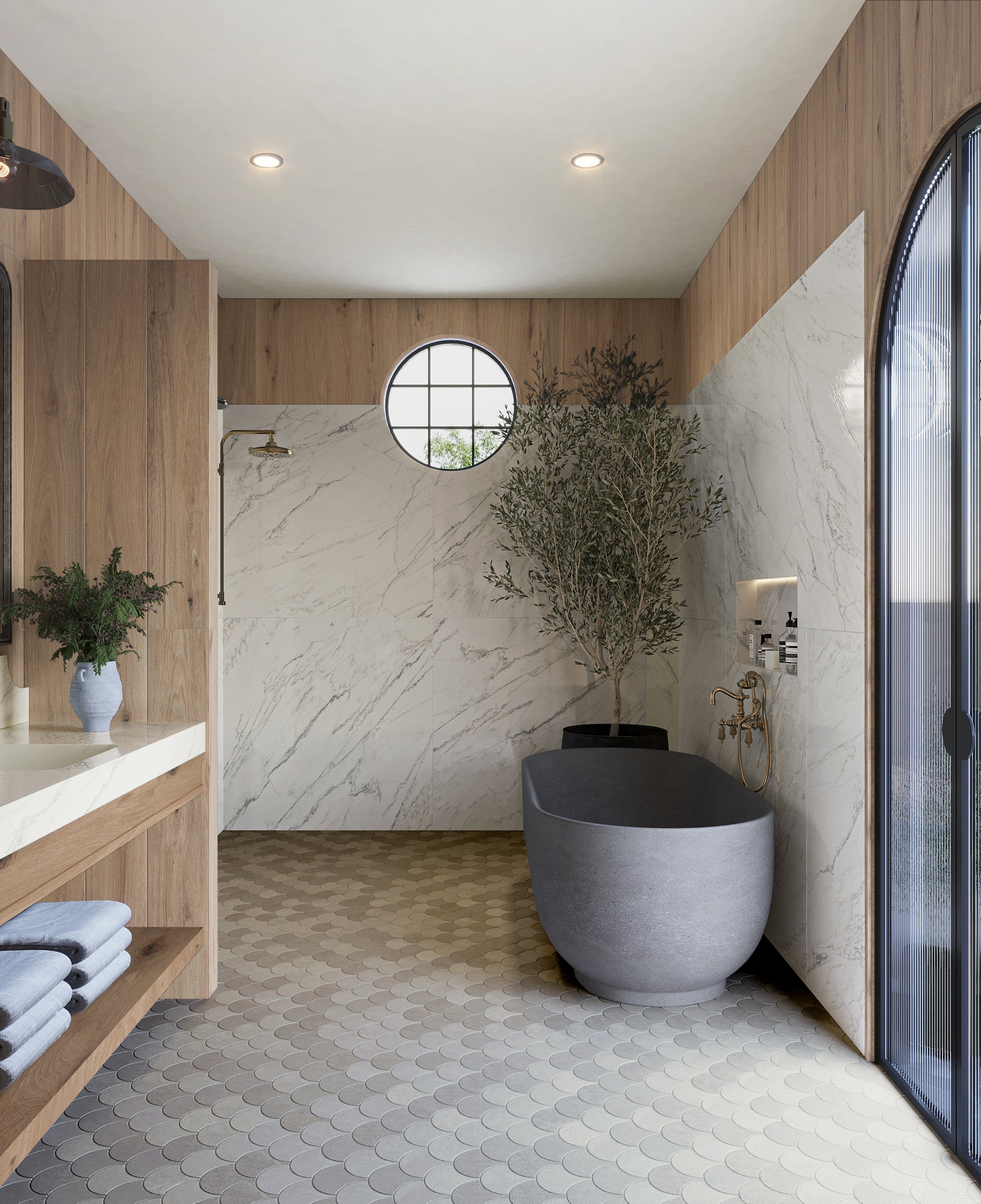 Modern bathroom featuring a freestanding gray tub, wood accents, marble walls, and a circular window adding natural light.