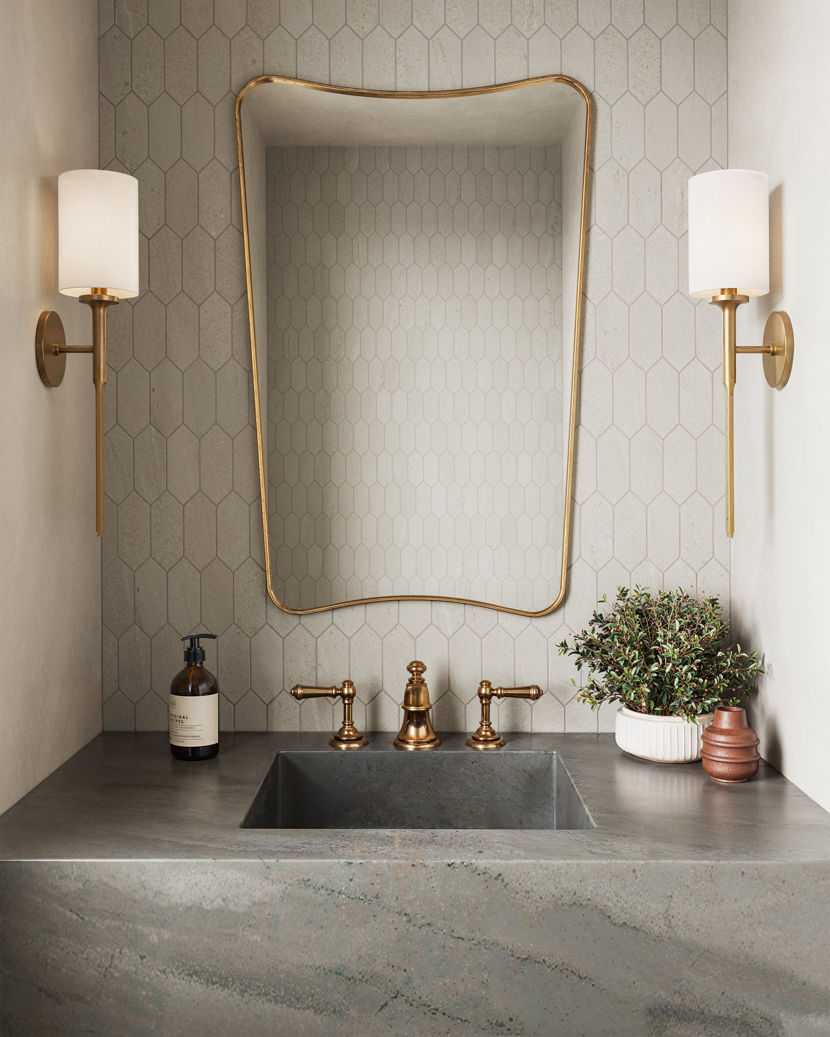 Elegant vanity setup with a beige picket tile backsplash, gold accents, and a dark stone sink, creating a luxurious and contemporary aesthetic.