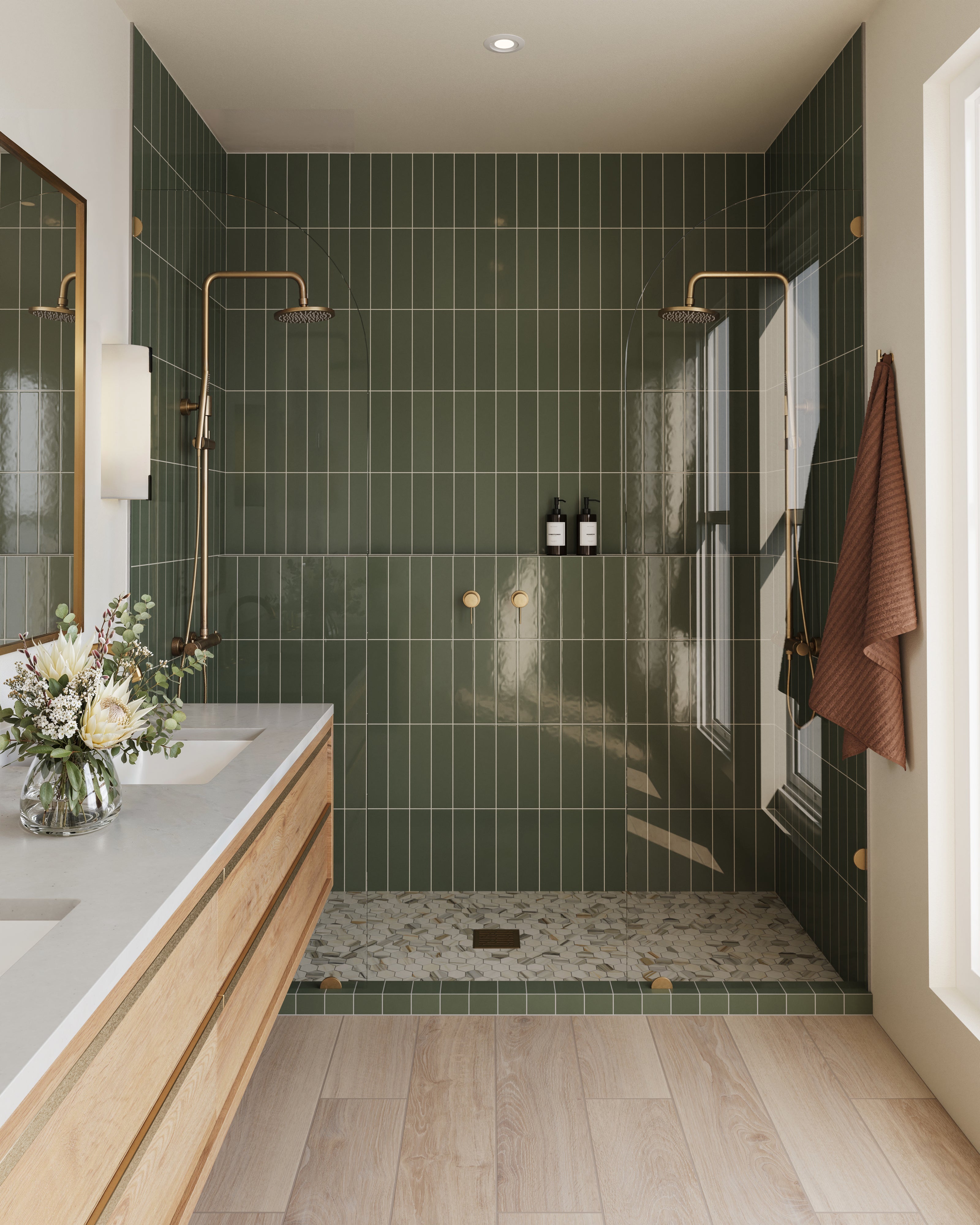 Stylish shower space featuring Teagan 3x12 glossy ceramic tiles in moss green, accented with gold fixtures and mosaic floor detailing.