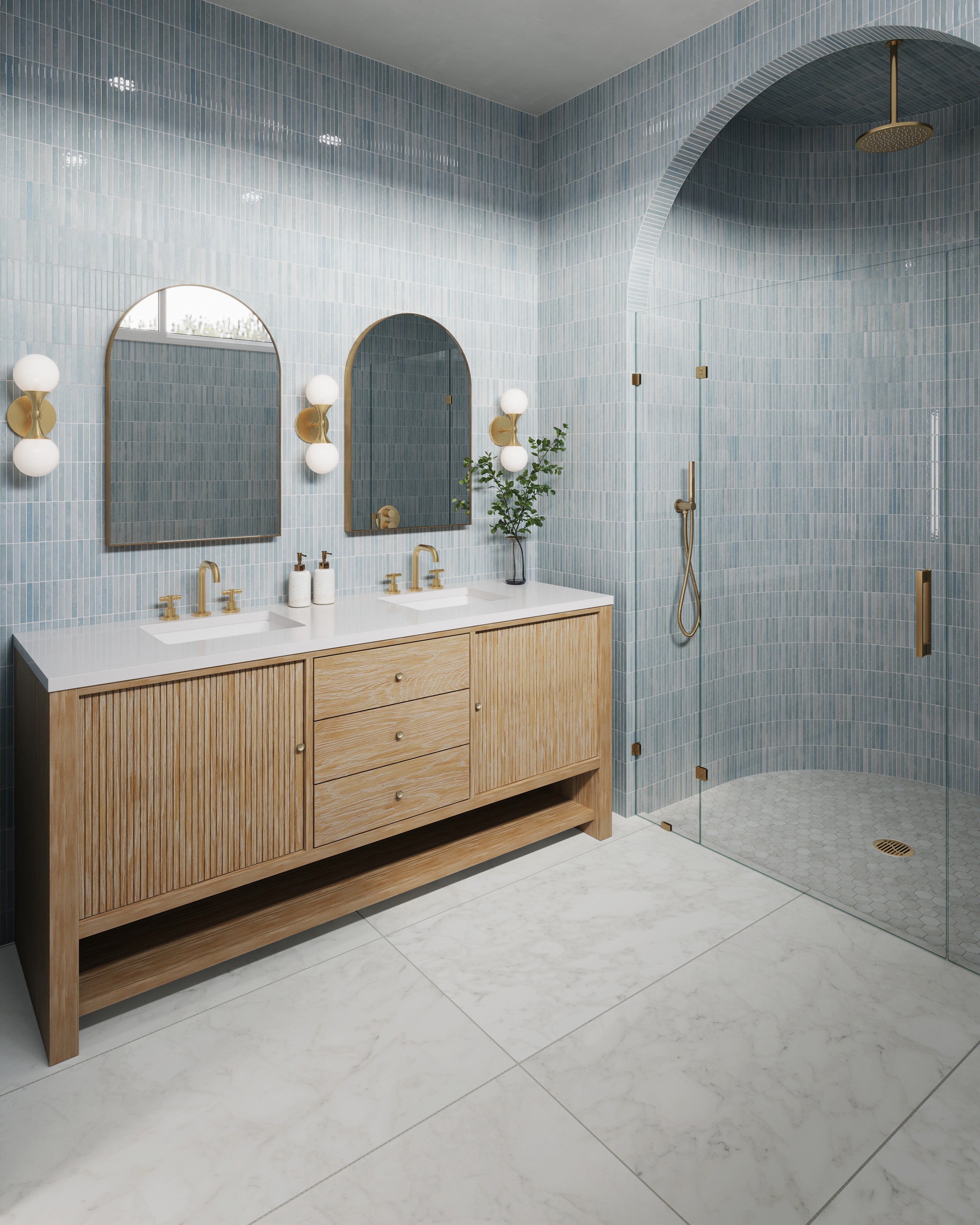 Bathroom with arched shower and walls clad in glossy ice blue tiles, paired with a sunwashed oak double vanity and brass fixtures like widespread faucets, arched mirrors, and two light wall sconces