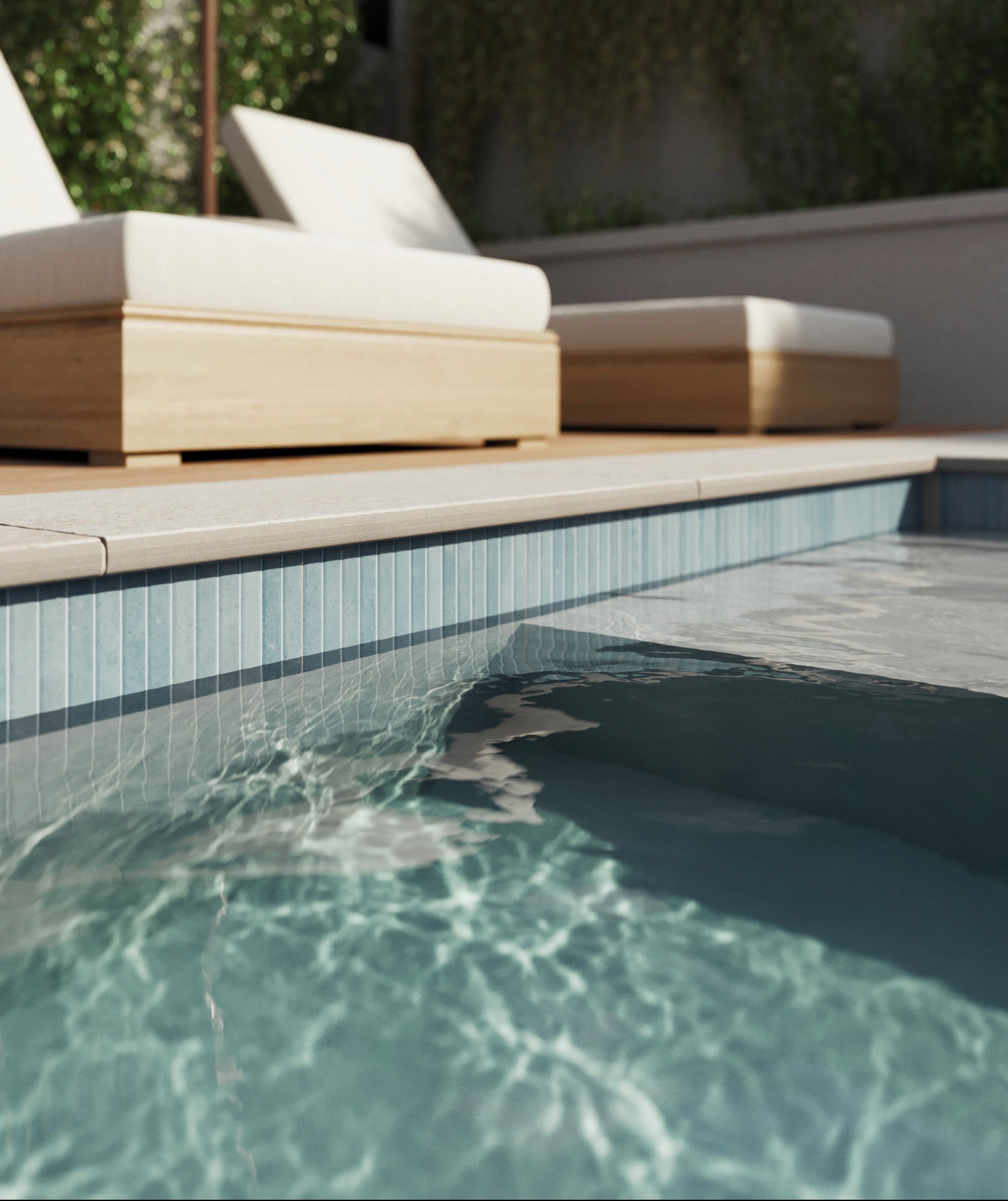 Close-up of a serene pool edge lined with Bowden Canvas 24x24 2CM Grip tiles in a cream finish, complemented by wooden loungers under a shaded umbrella.