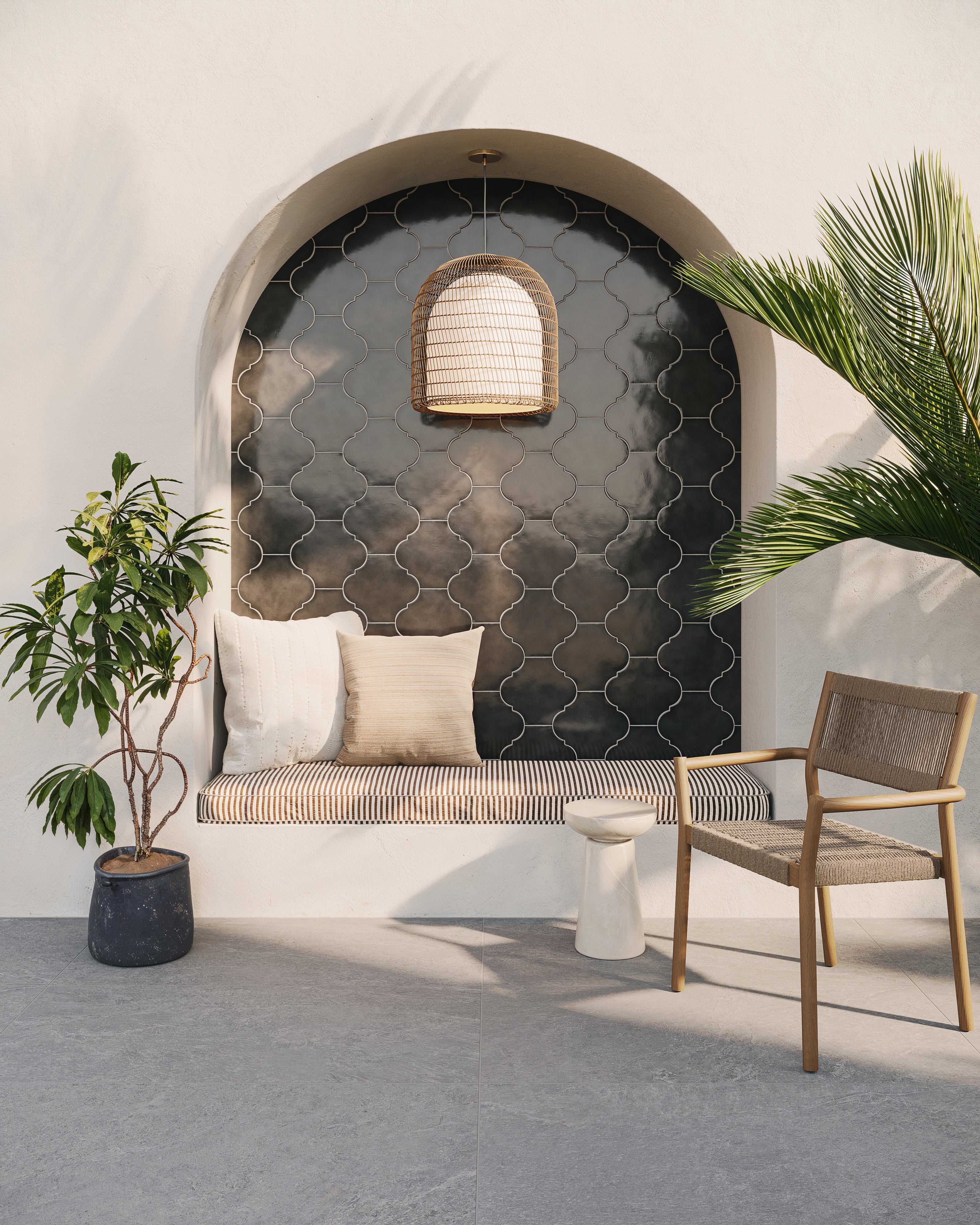 Arched wall niche featuring glossy black porcelain lantern tiles, a woven pendant light, cushioned bench seating, and lush indoor plants.