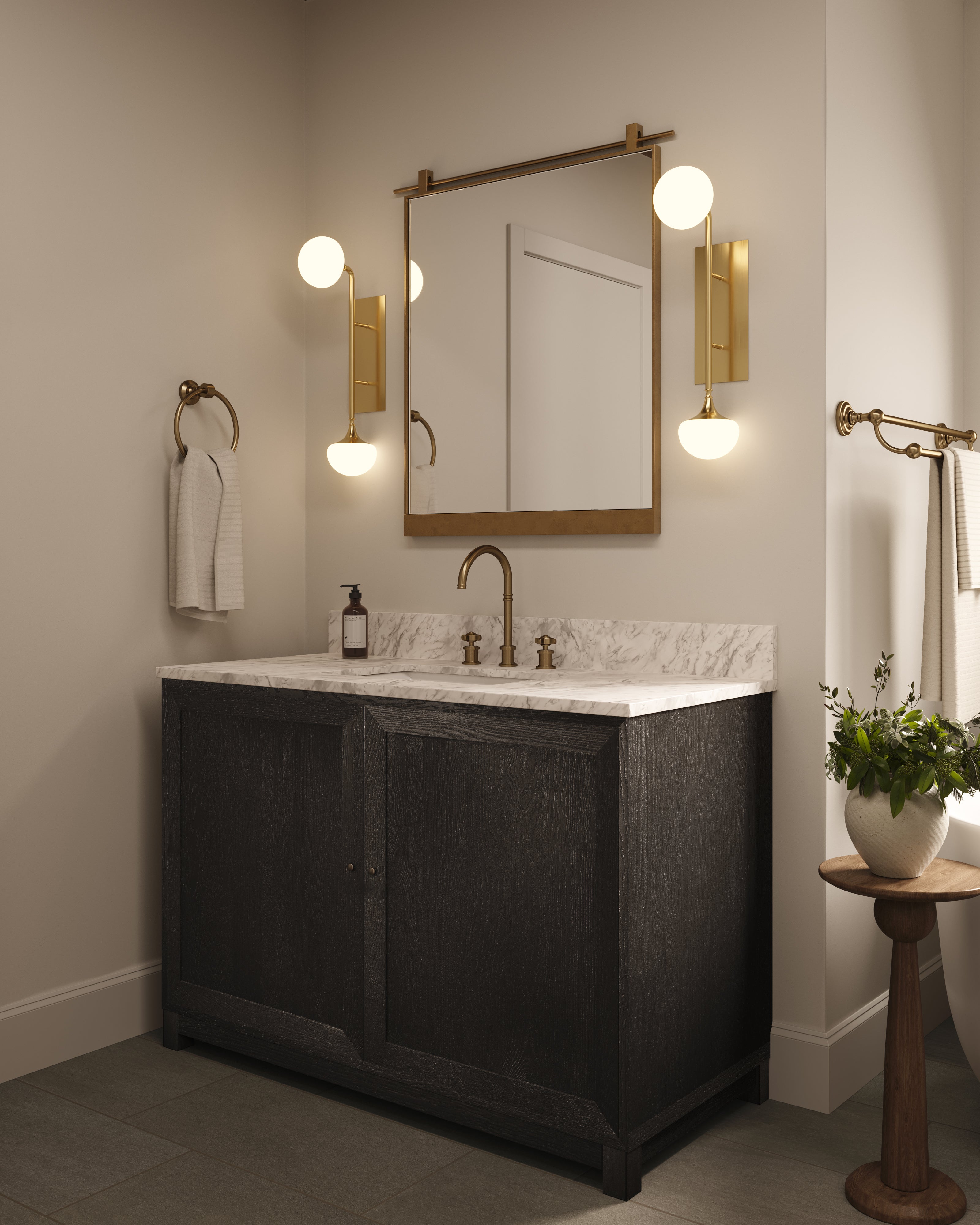 Bathroom with a dark wood vanity, marble countertop, and two aged brass wall sconces flanking a mirror, featuring brass fixtures.