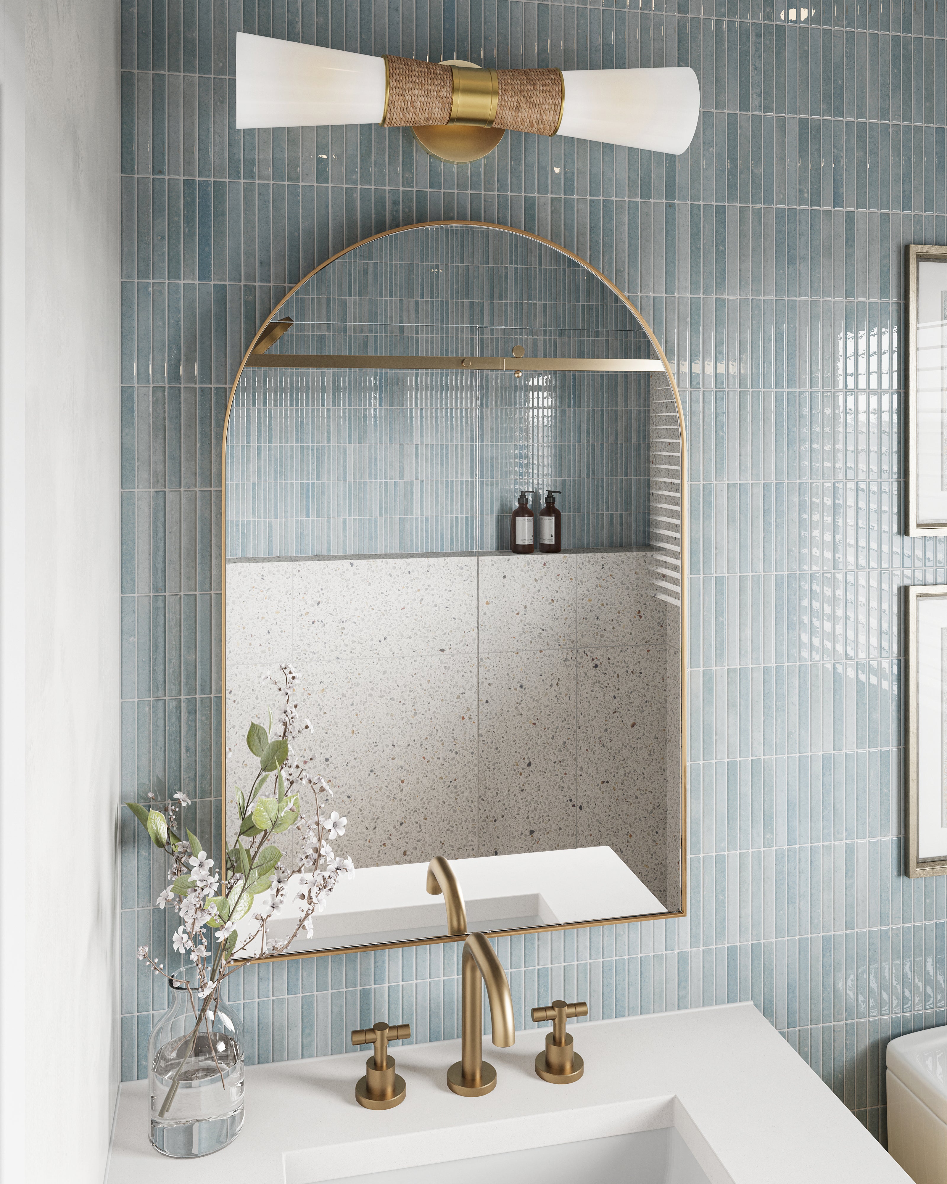Vintage brass arched mirror and raffia-wrapped sconce pop against glossy sky-blue backsplash tile in a serene bath vignette.