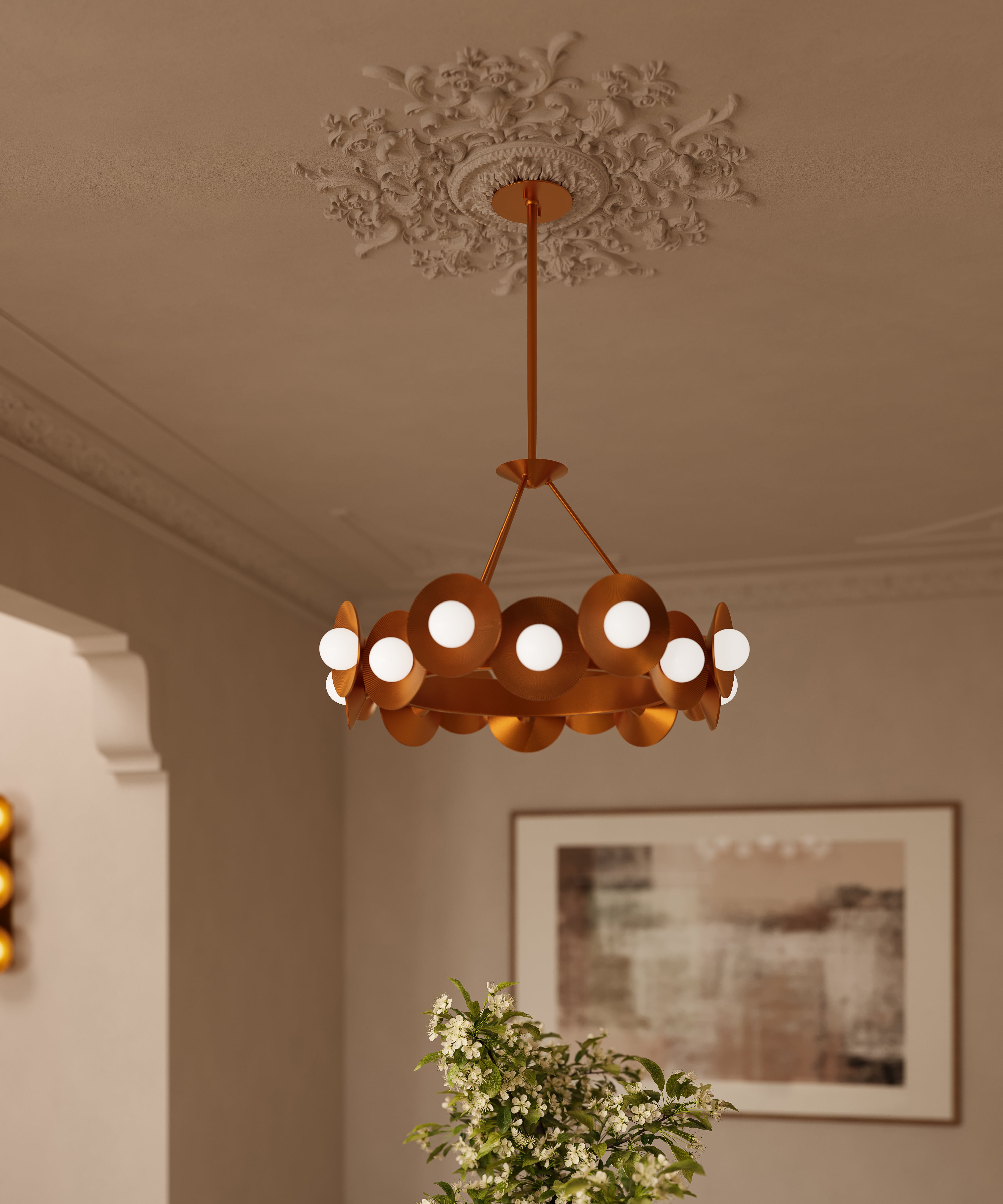 Vintage gold leaf chandelier with circular disc shades and globe bulbs suspended from an ornate ceiling medallion in an elegant room.