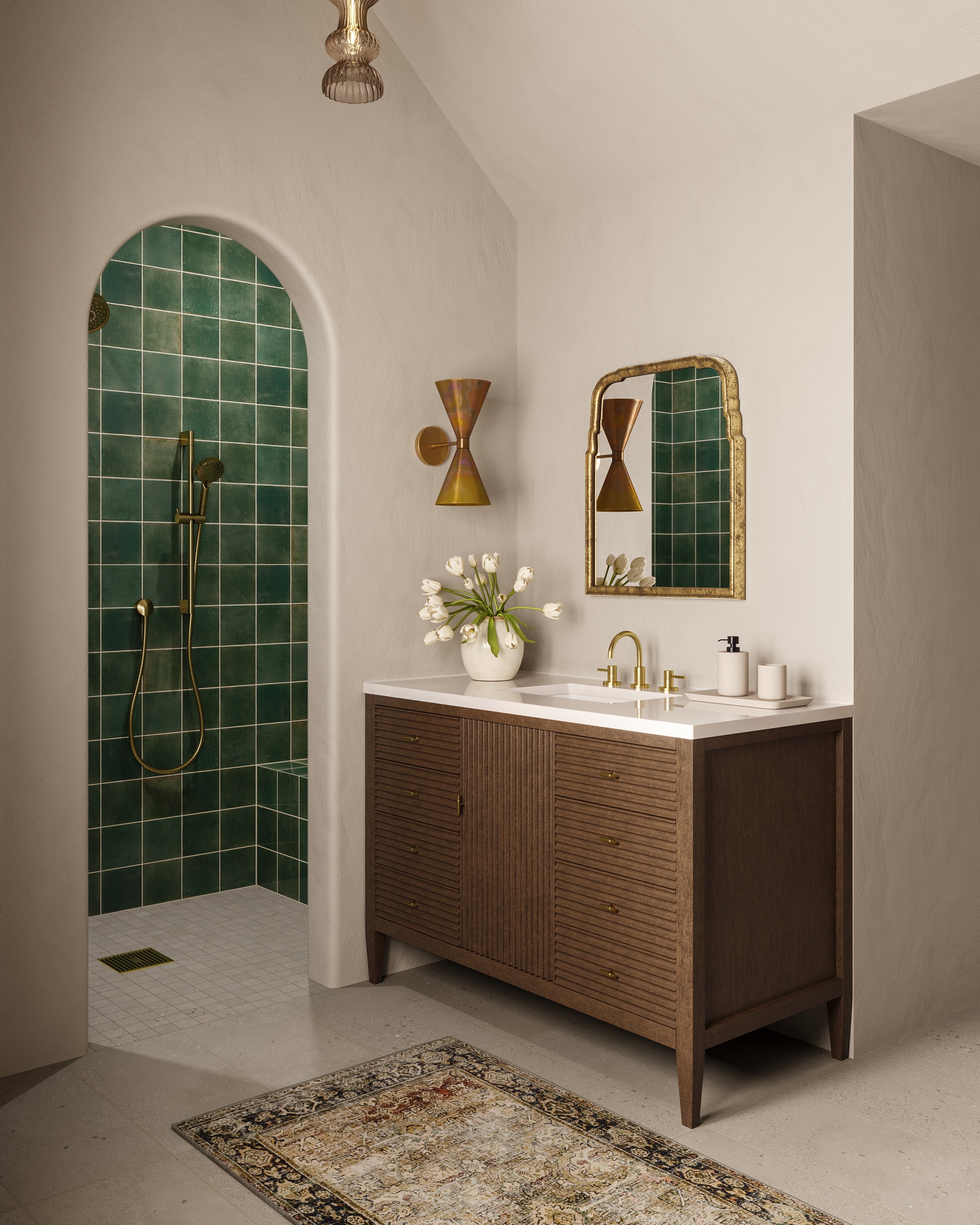 Vanity and mirror set beside a walk-in shower lined with rustic dark green porcelain tiles, highlighted by warm gold fixtures.