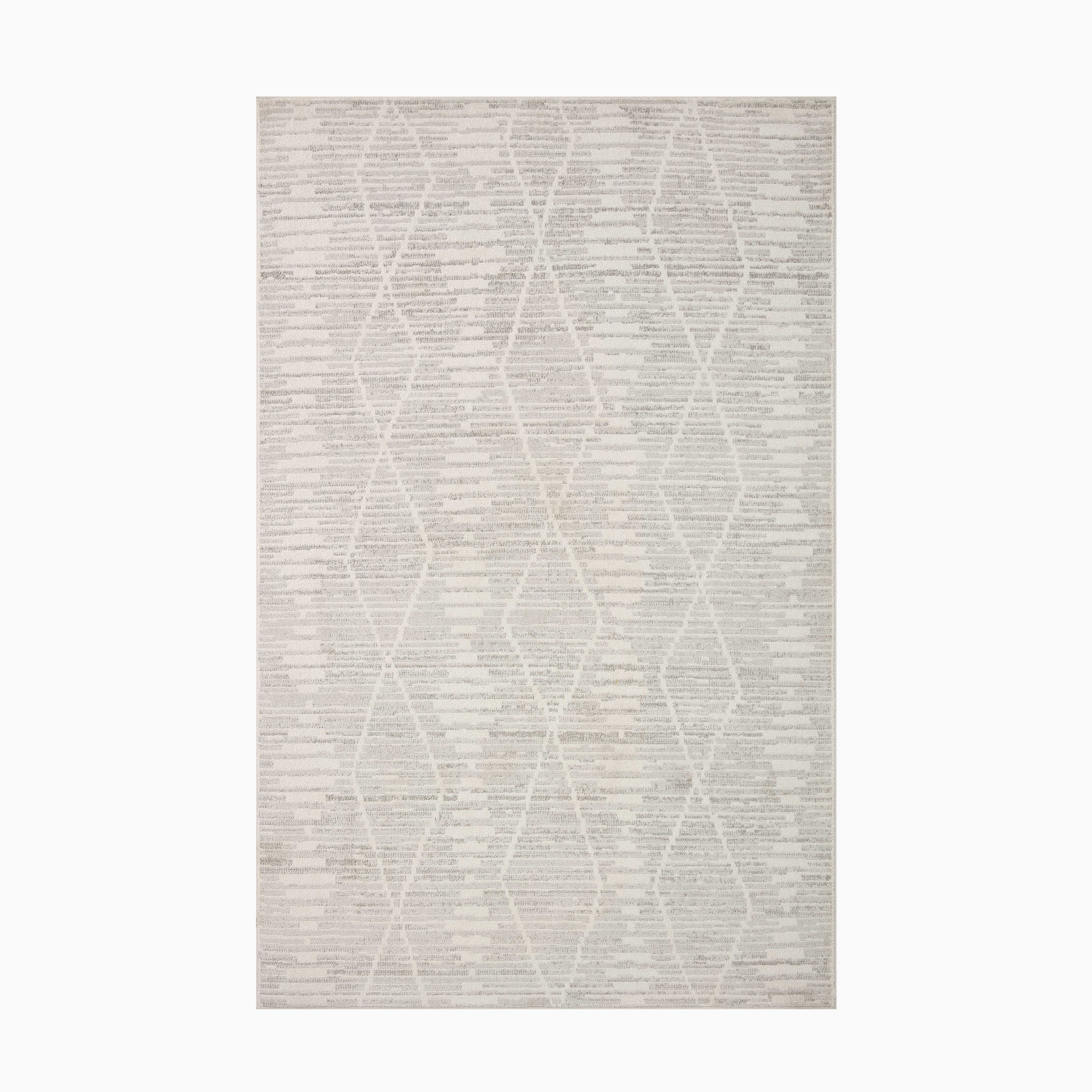 Crafted from durable polyester, this power-loomed transitional rug blends an ivory-toned background with subtle beige details, creating a serene and sophisticated feel.