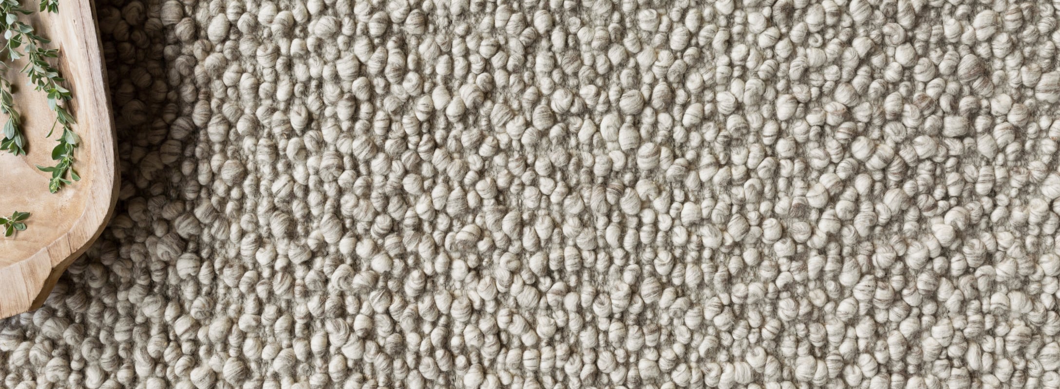 Close-up of a hand-woven rug with plush, textured loops in a soft neutral tone, exuding warmth and artisanal craftsmanship.