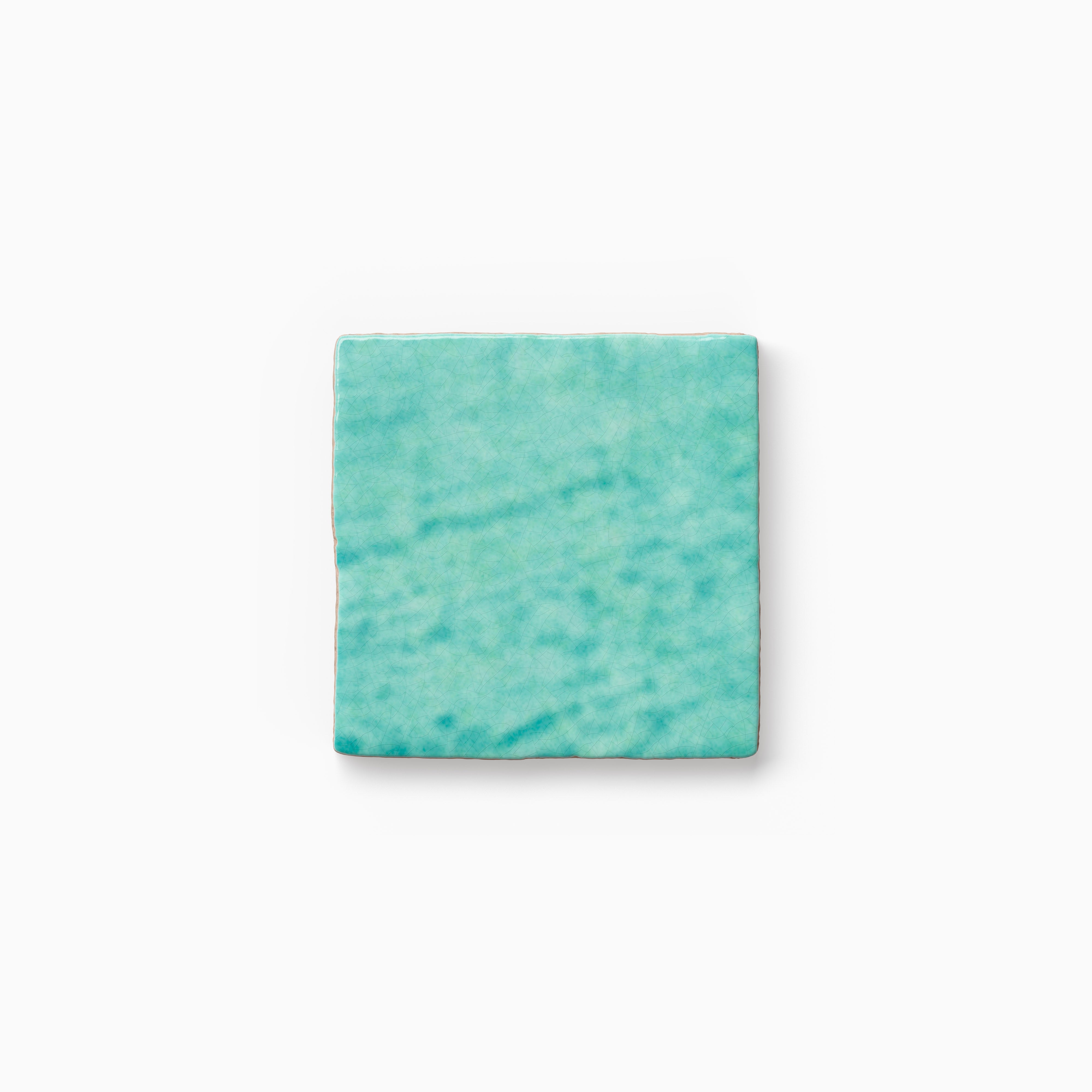 Square turquoise tile sample featuring layered color movement, subtle texture, and a handcrafted appearance on a neutral backdrop.