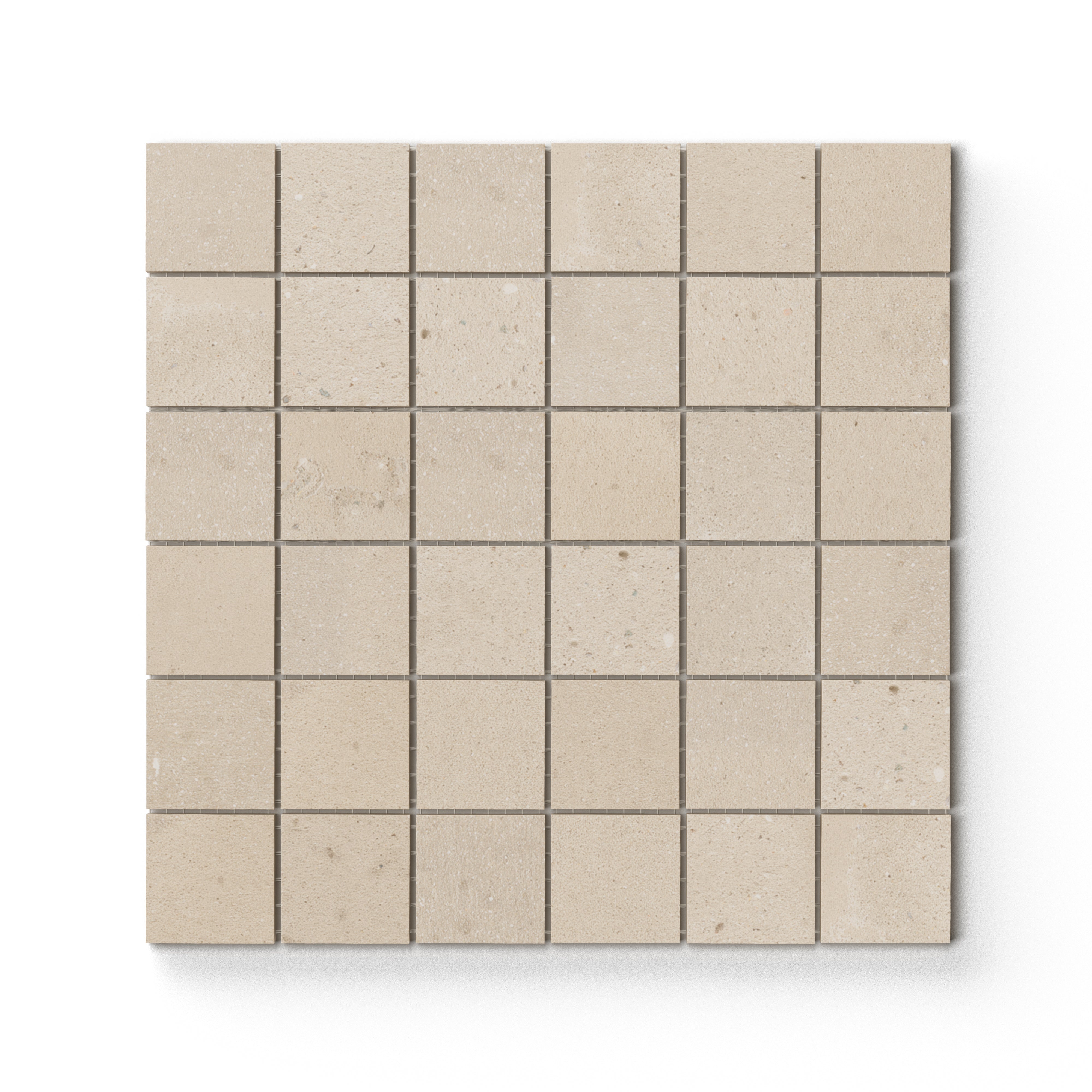 Warm beige matte porcelain mosaic tile in a mesh-mounted square format, featuring visual mineral flecks inspired by the shifting texture of Italian Riviera sand.