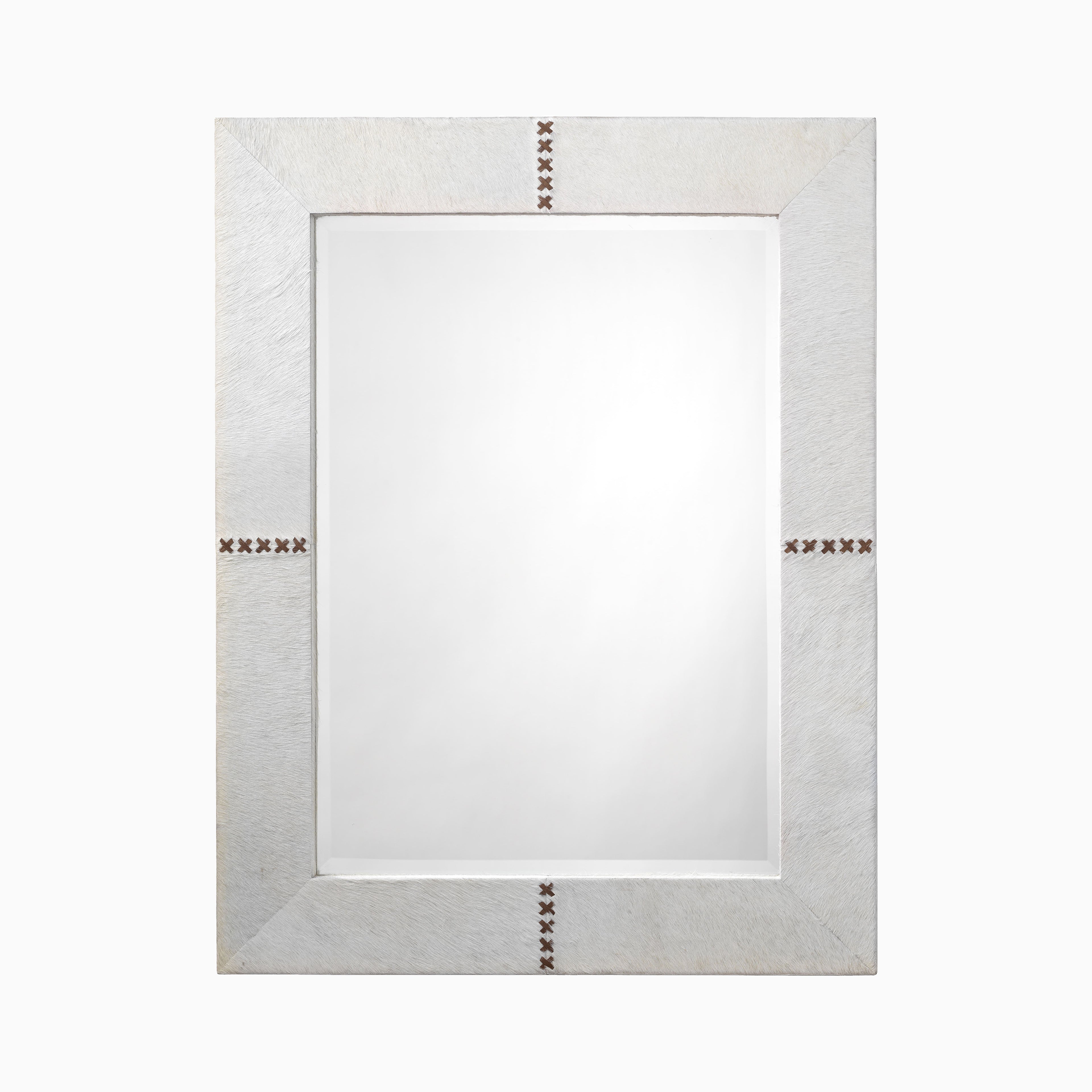 Rectangular mirror framed in white hair-on cowhide with organic texture and brown leather whip-stitch accents inspired by traditional saddlework.