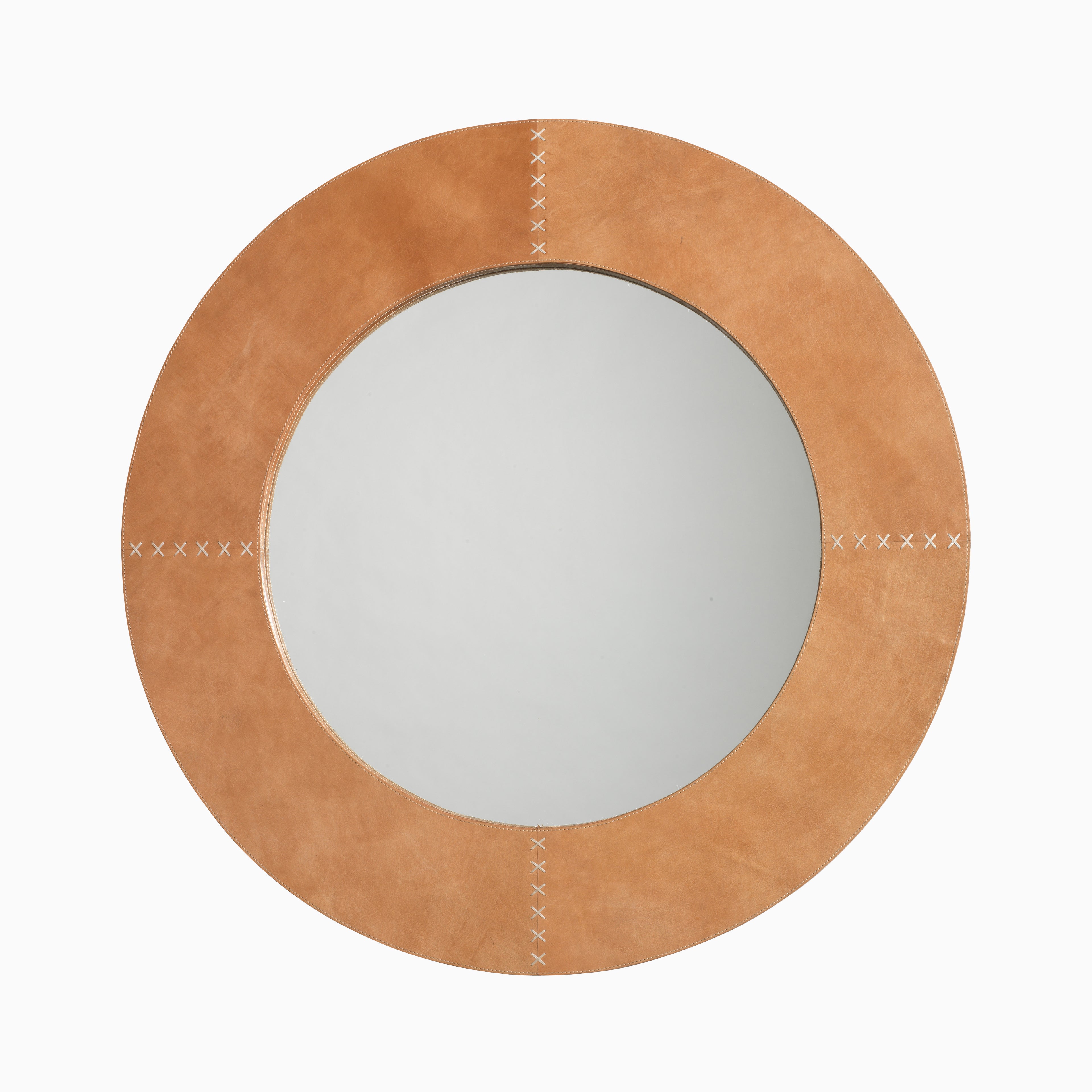 Round mirror wrapped in light brown cowhide featuring natural tonal shifts and white leather whip-stitch detailing with saddle-inspired accents.
