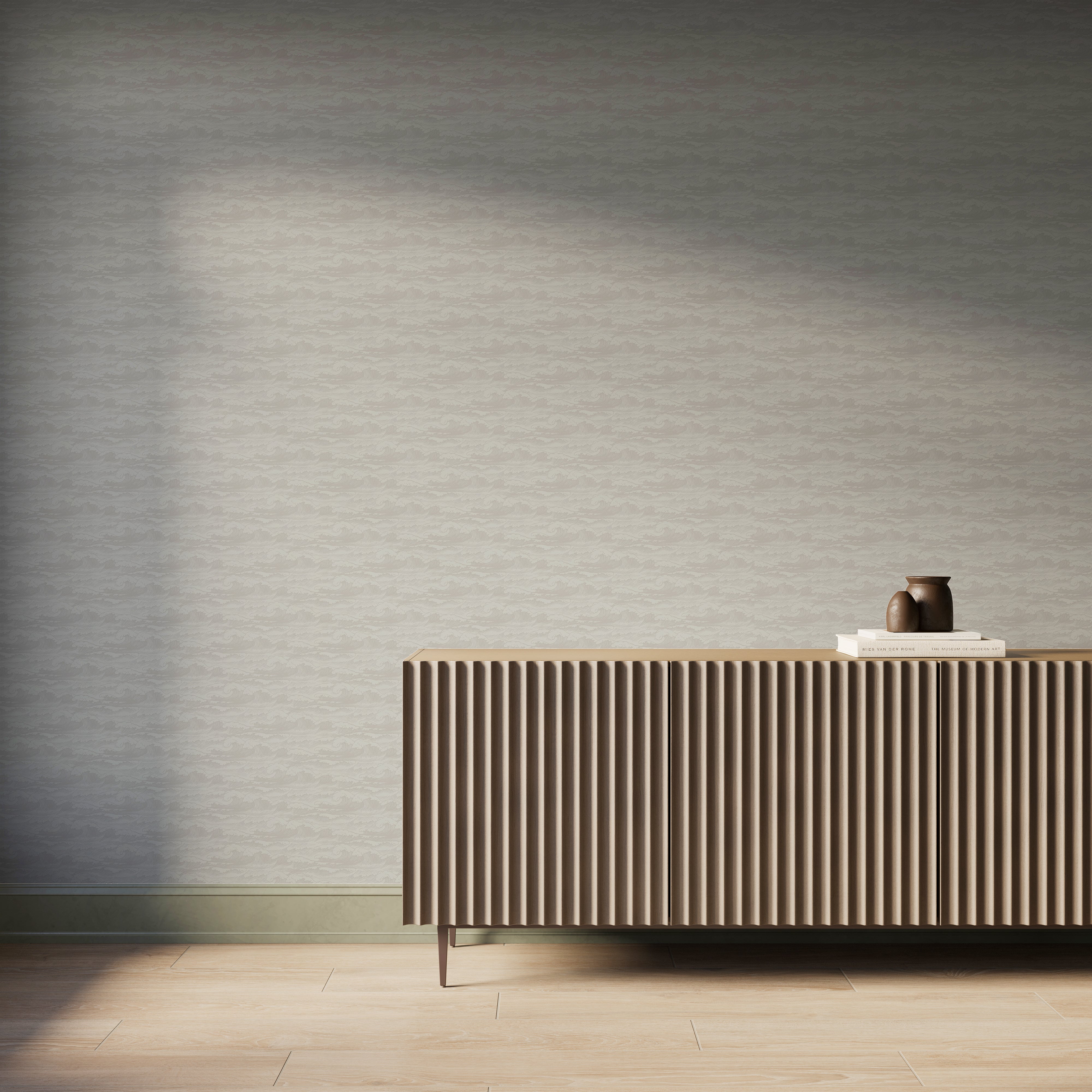 Beige and light gray wave-pattern wallpaper behind a modern ribbed wood sideboard with books and pottery in a calm coastal room.