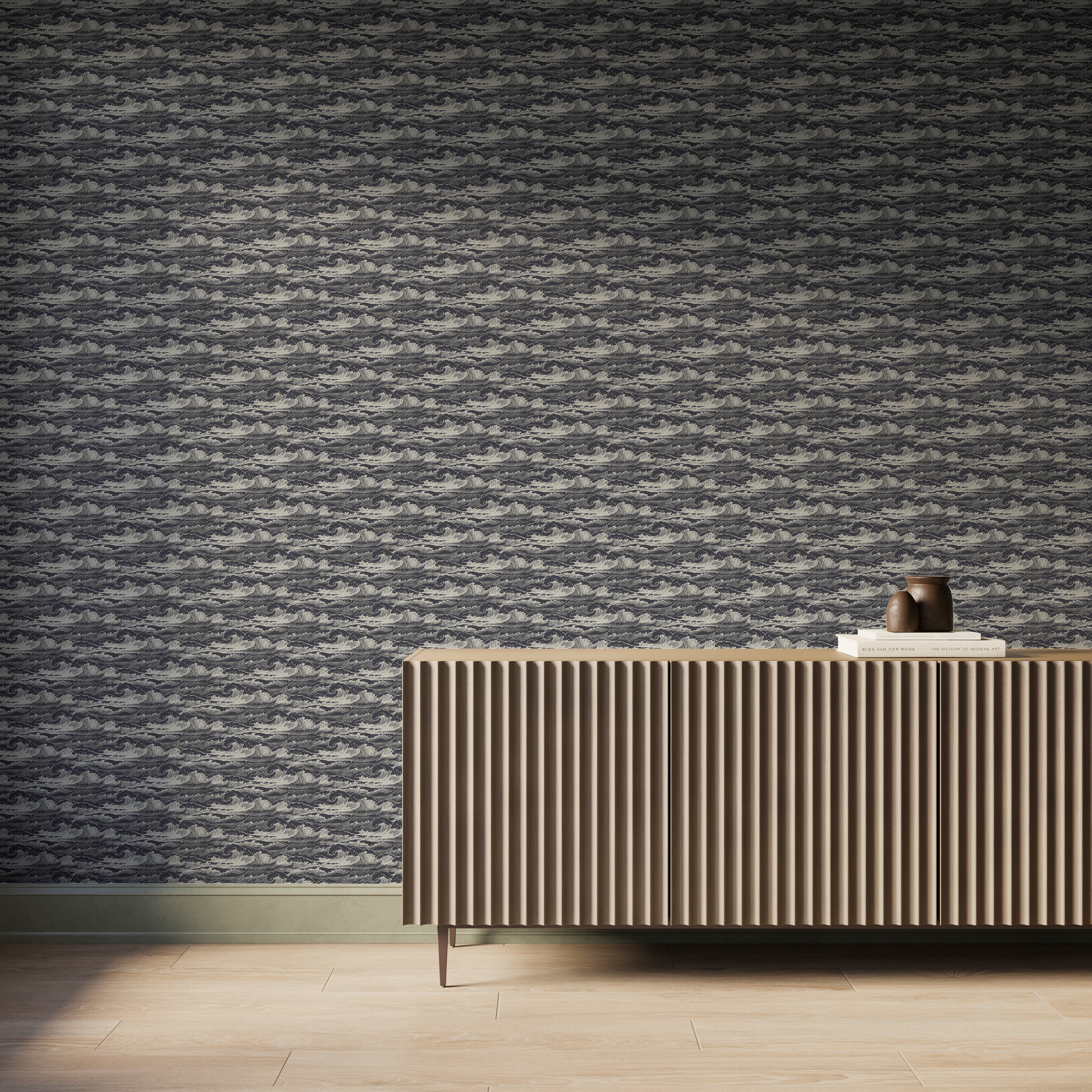Dark navy wave-pattern wallpaper behind a modern ribbed wood sideboard with books and pottery in a warm coastal-inspired room.