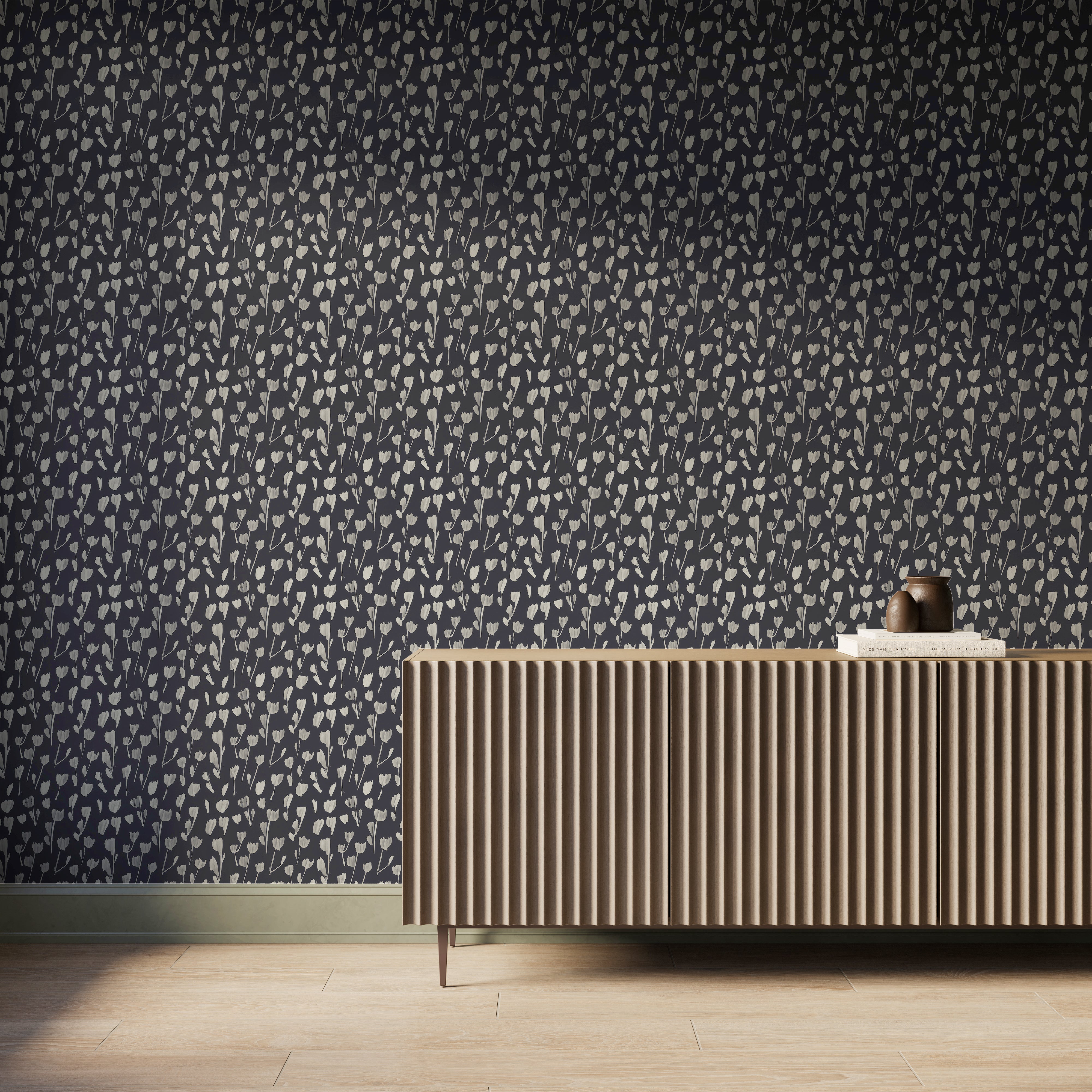 A wall with Petaline wallpaper Black II shows soft off-white floral silhouettes across a black background behind a fluted wood console, ideal for contemporary interiors.