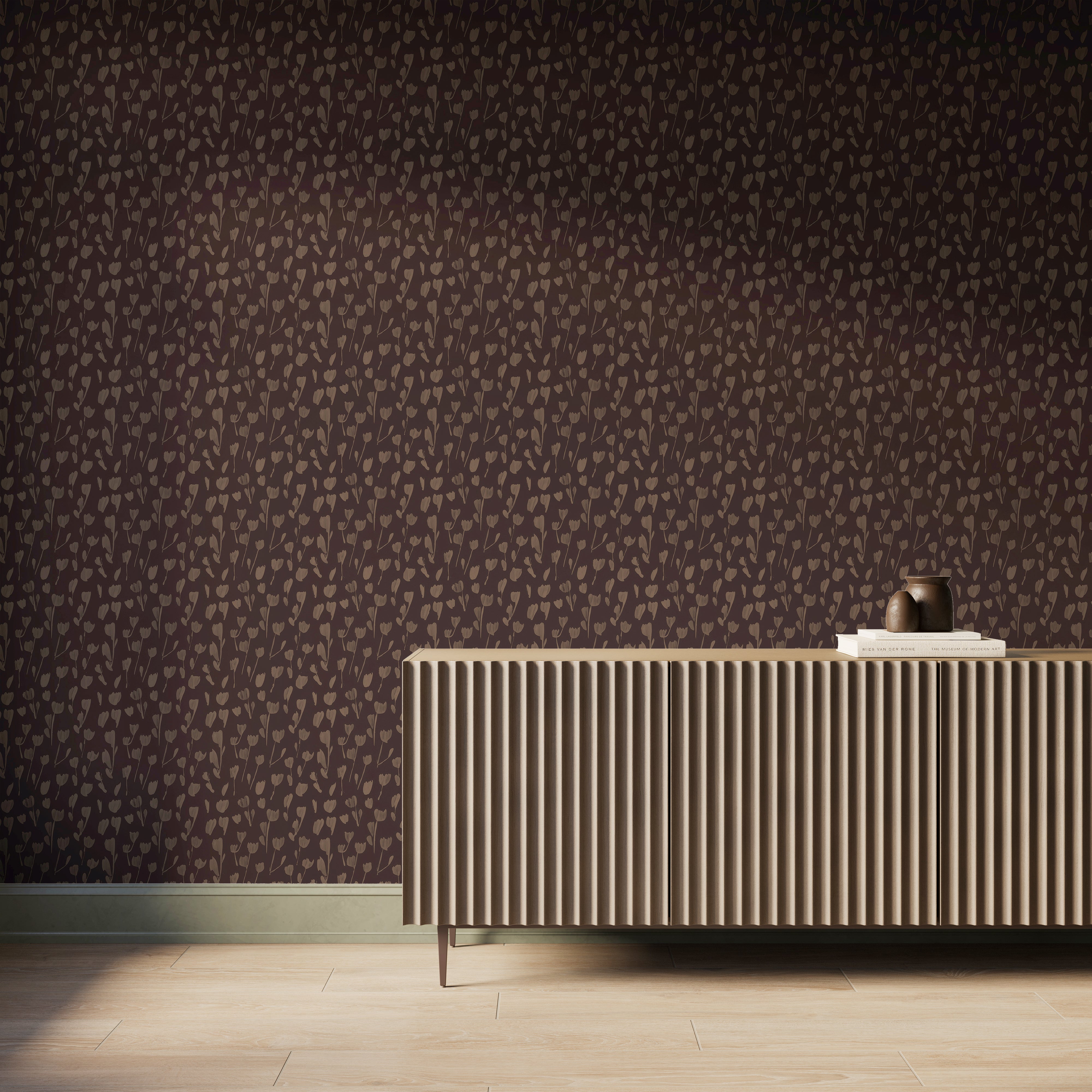A wall styled with Petaline wallpaper in Black/Tan II shows soft dark brown floral silhouettes on a black background behind a fluted wood console in a modern interior.