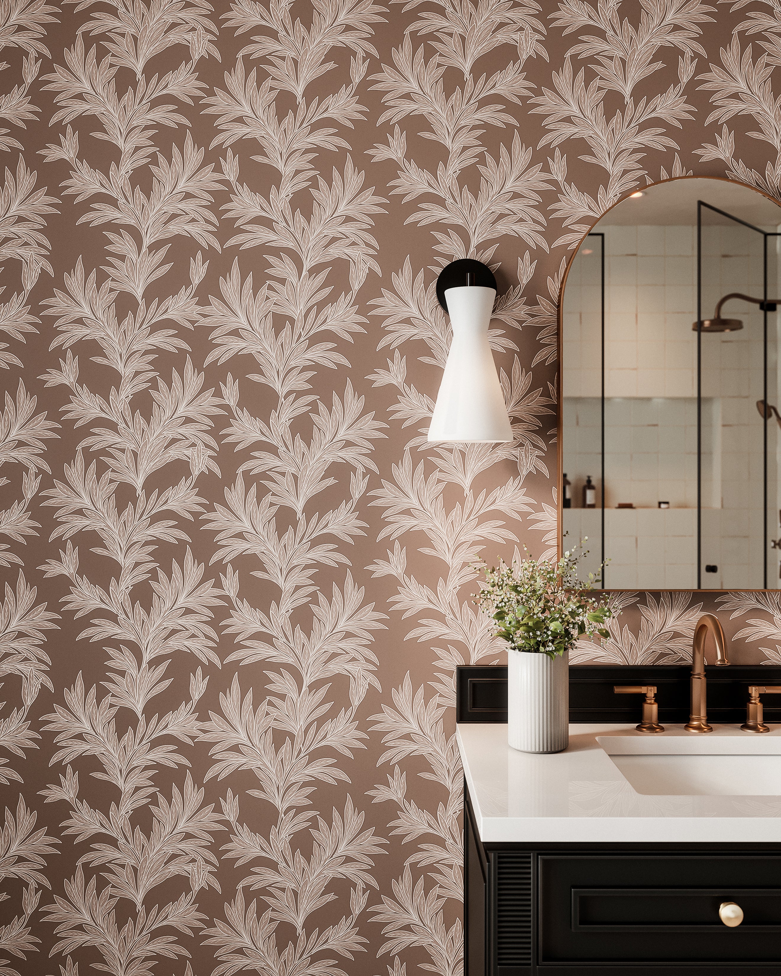 Modern bathroom vanity with black cabinet, brass faucet, botanical wallpaper, and white glass wall sconce.