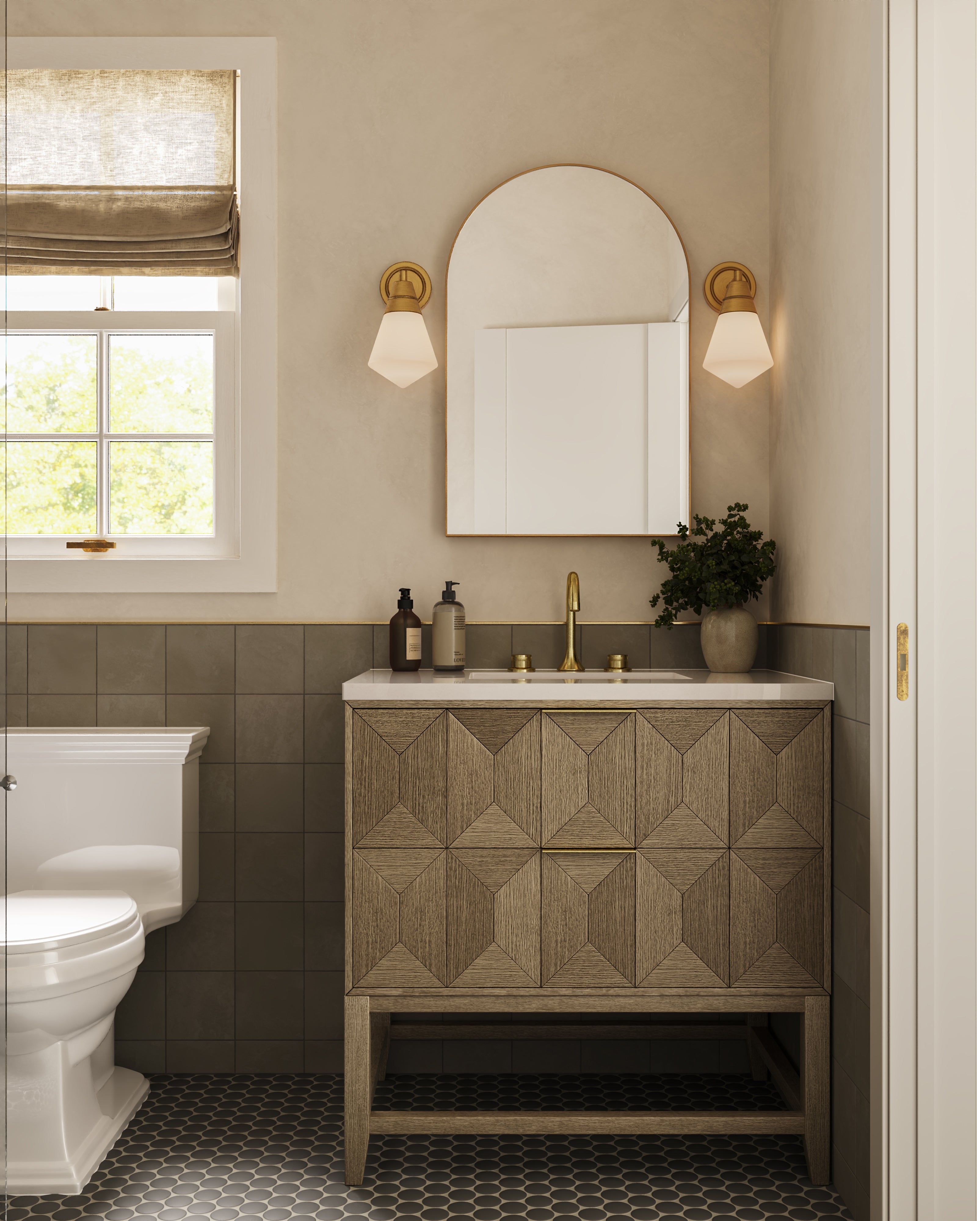 Matching brushed gold wall lights with faceted frosted glass shades illuminating a bathroom vanity with an arched mirror and textured wood cabinetry.