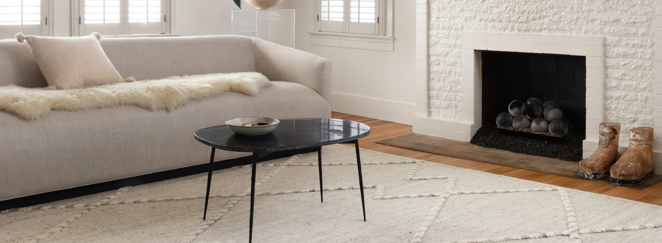 Contemporary white area rug with textured geometric patterns, enhancing a cozy living room featuring a soft sofa and a modern fireplace