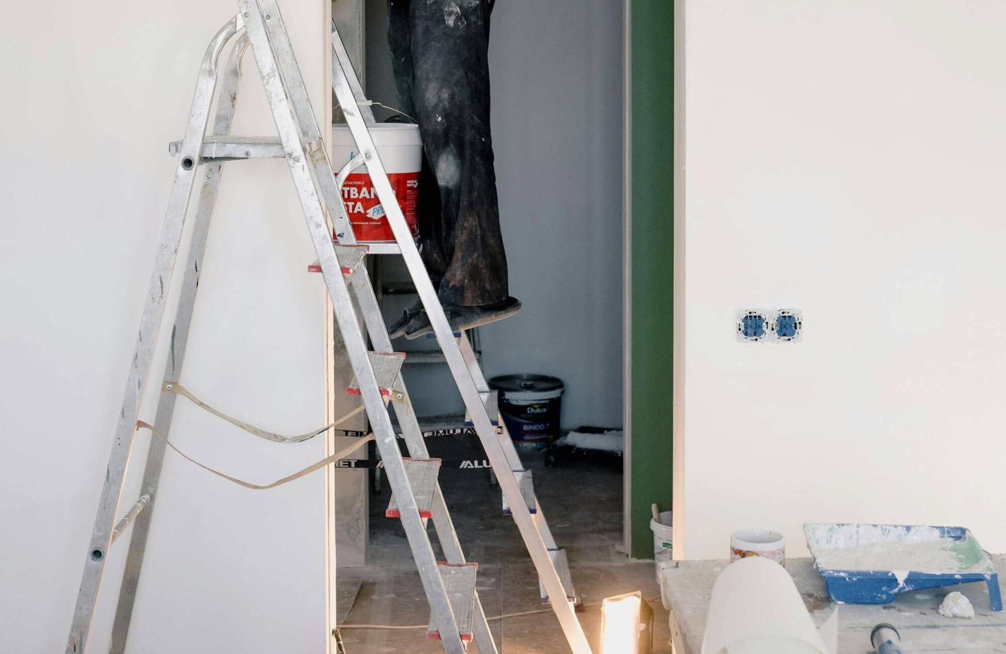 Partially renovated bathroom with ladder, tools, and exposed walls showing an in-progress DIY remodeling project.