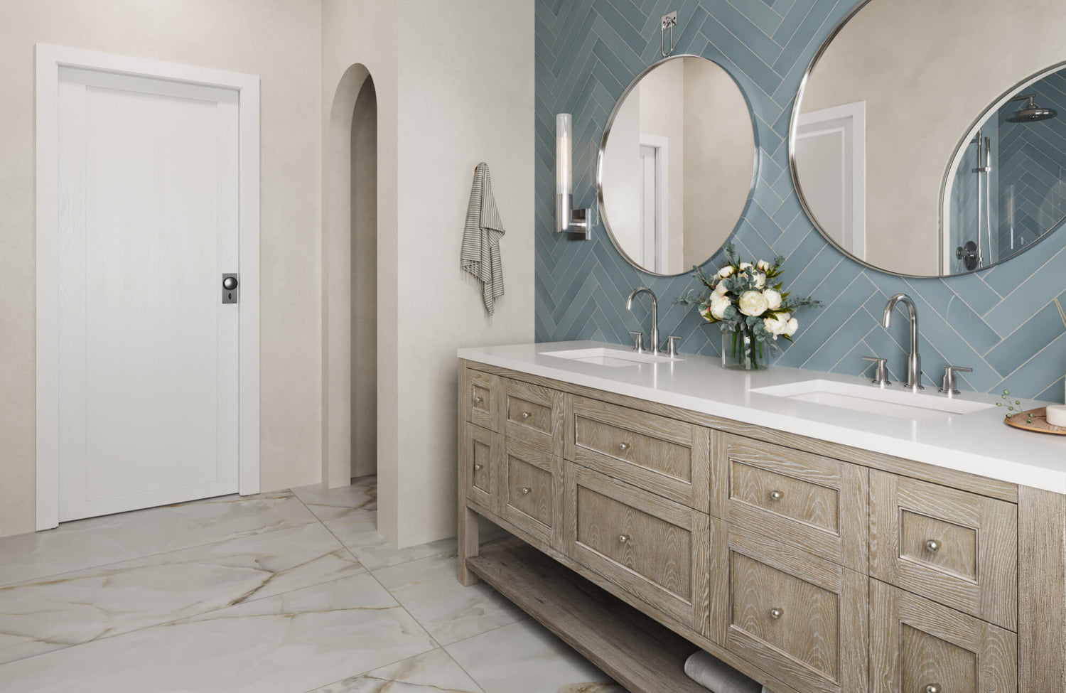 Double-sink vanity with light wood cabinets, white countertop, and round mirrors against a blue herringbone tile backsplash.