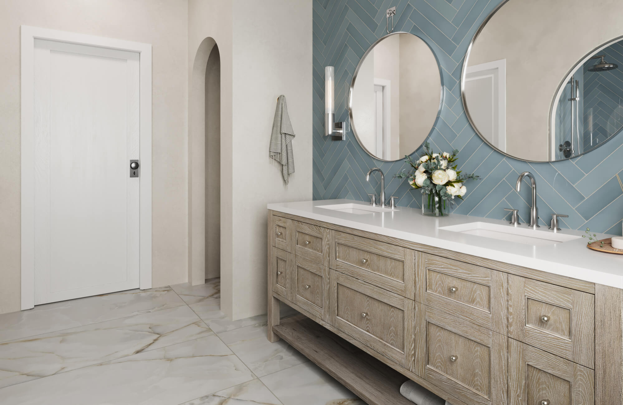 Double-sink vanity with light wood cabinets, white countertop, and round mirrors against a blue herringbone tile backsplash.