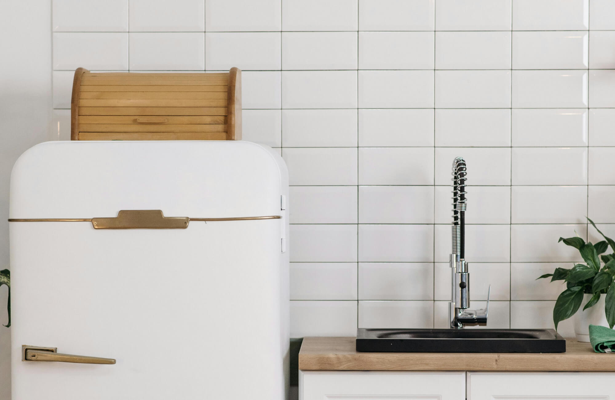 Glossy white subway tiles with subtle beveling create a clean, timeless backsplash in this modern kitchen.
