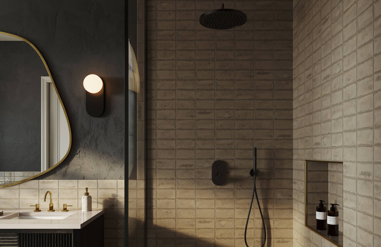 Moody bathroom with textured beige wall subway tiles, matte black shower fittings, and a globe wall sconce beside a sculptural mirror.