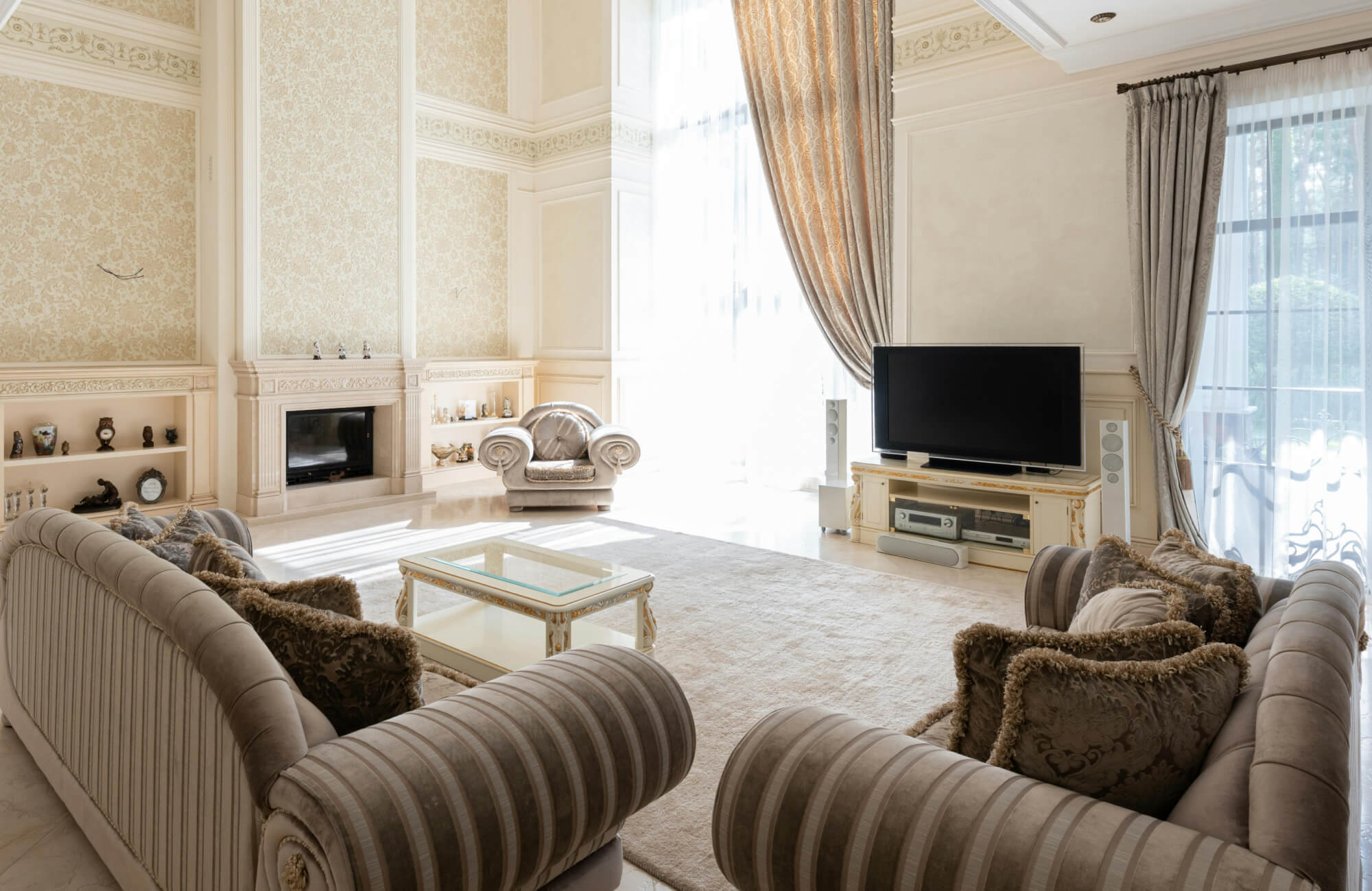 Bright, elegant living room featuring a soft cream rug that anchors the classic sofas, complements refined furnishings, and enhances the warm, light-filled space.
