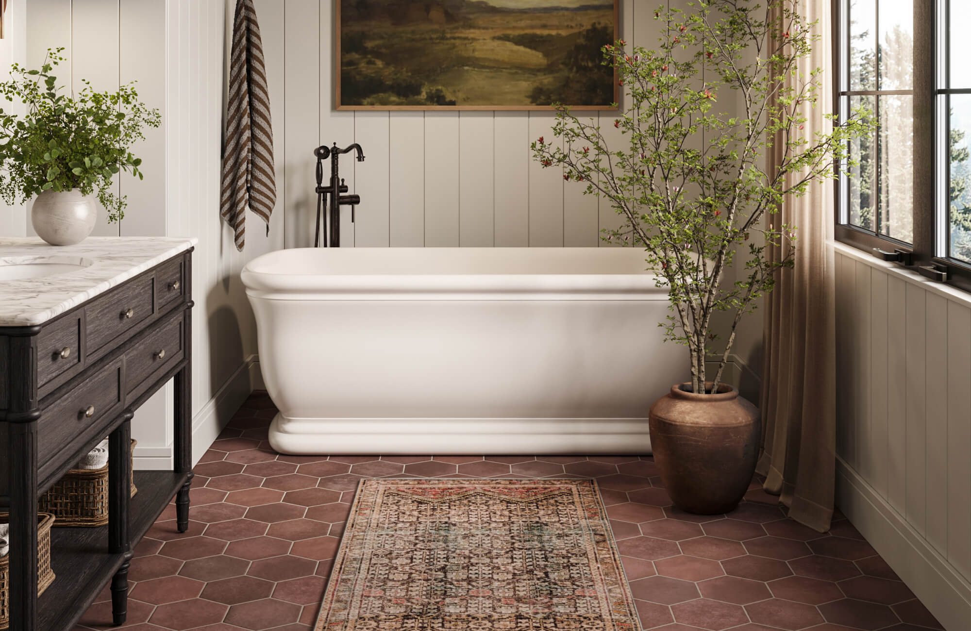 Freestanding white bathtub with vintage bronze fixtures, set on terracotta hexagon tiles beside a large potted branch.