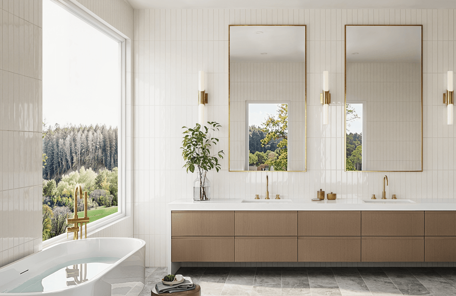 Elegant bathroom with vertical white wall tile, brass fixtures, double vanity with tall mirrors, and a soaking tub by a scenic picture window.