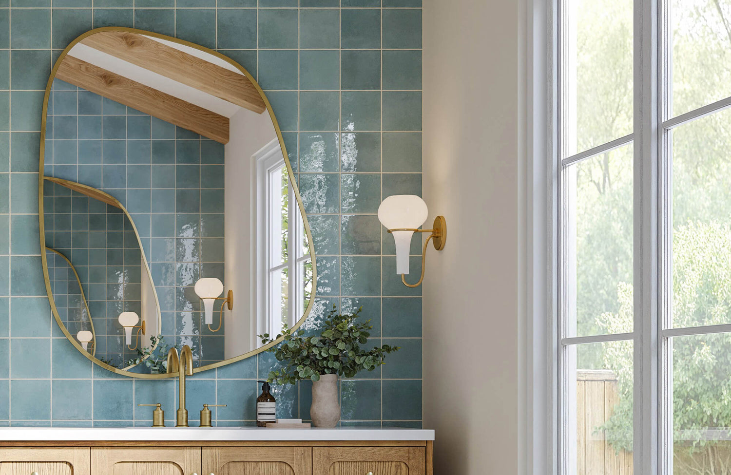 Elegant bathroom with glossy square backsplash tiles, gold fixtures, and a curved mirror reflecting natural light.