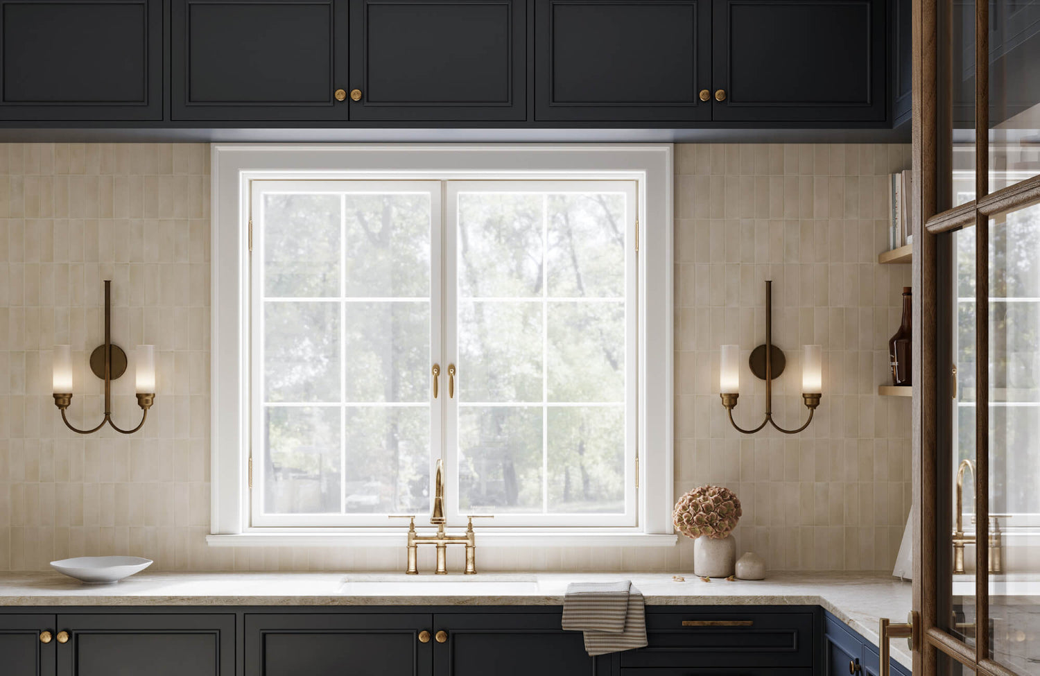 Modern kitchen with black cabinetry, brass fixtures, and dual brass sconces flanking a large window above a marble countertop.