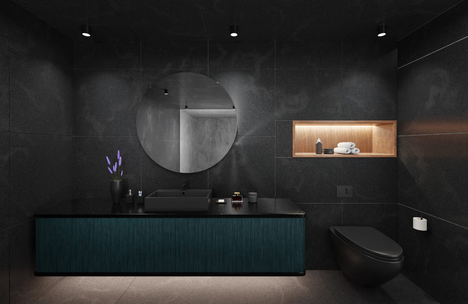 Modern black-tiled bathroom with a circular mirror, matte black fixtures, a built-in wooden shelf, and teal vanity under soft lighting.