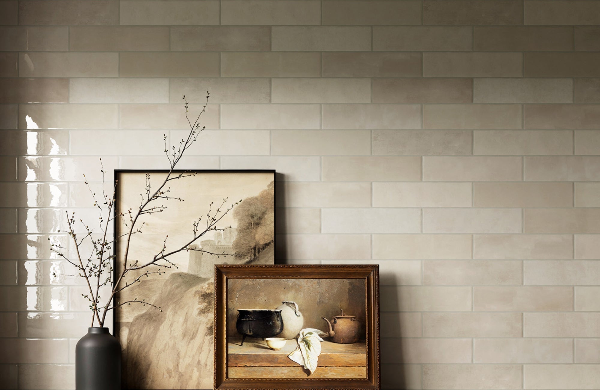Beige ceramic subway tiles with soft neutral grout lines, styled with artwork and dried branches on display.