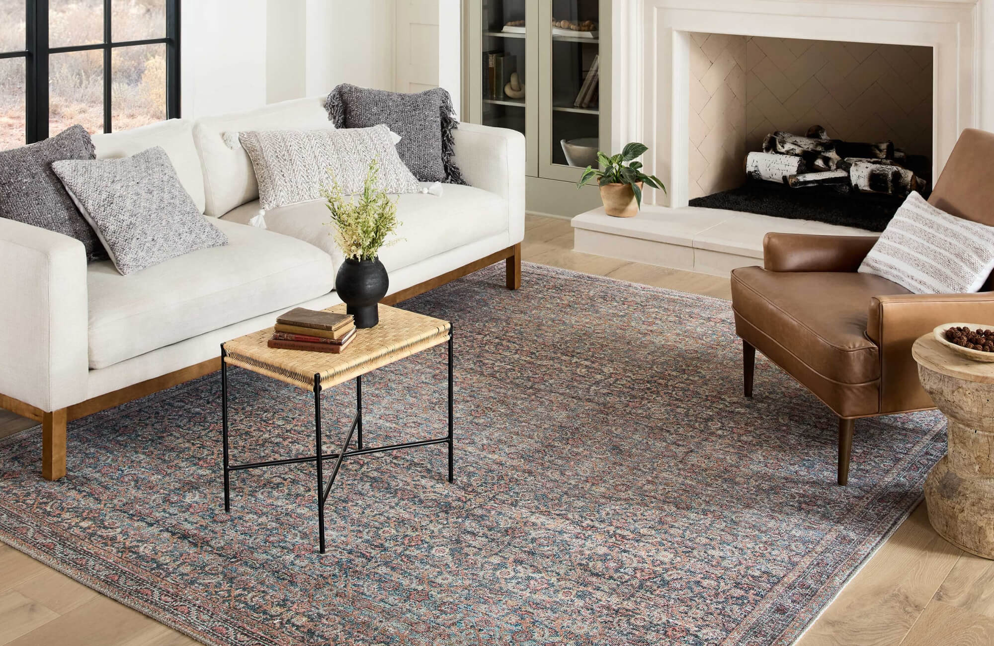 Sofa with layered pillows, larger cushions at the back, and smaller decorative pillows placed neatly in front.