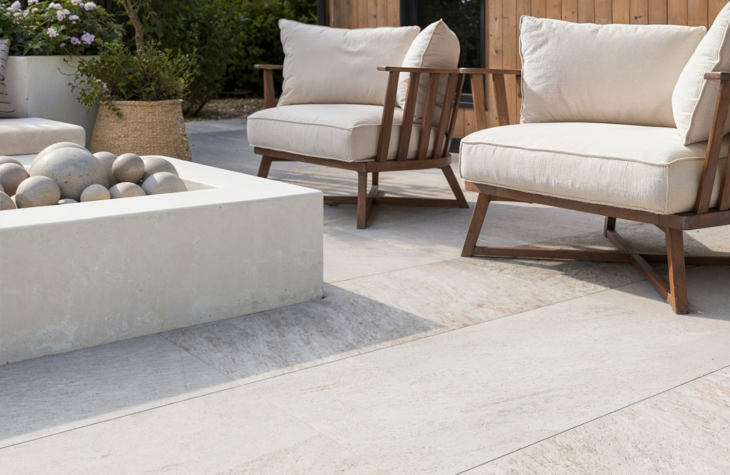 Outdoor seating area with large porcelain pavers surrounding a modern fire pit, showing clean edging and layout.