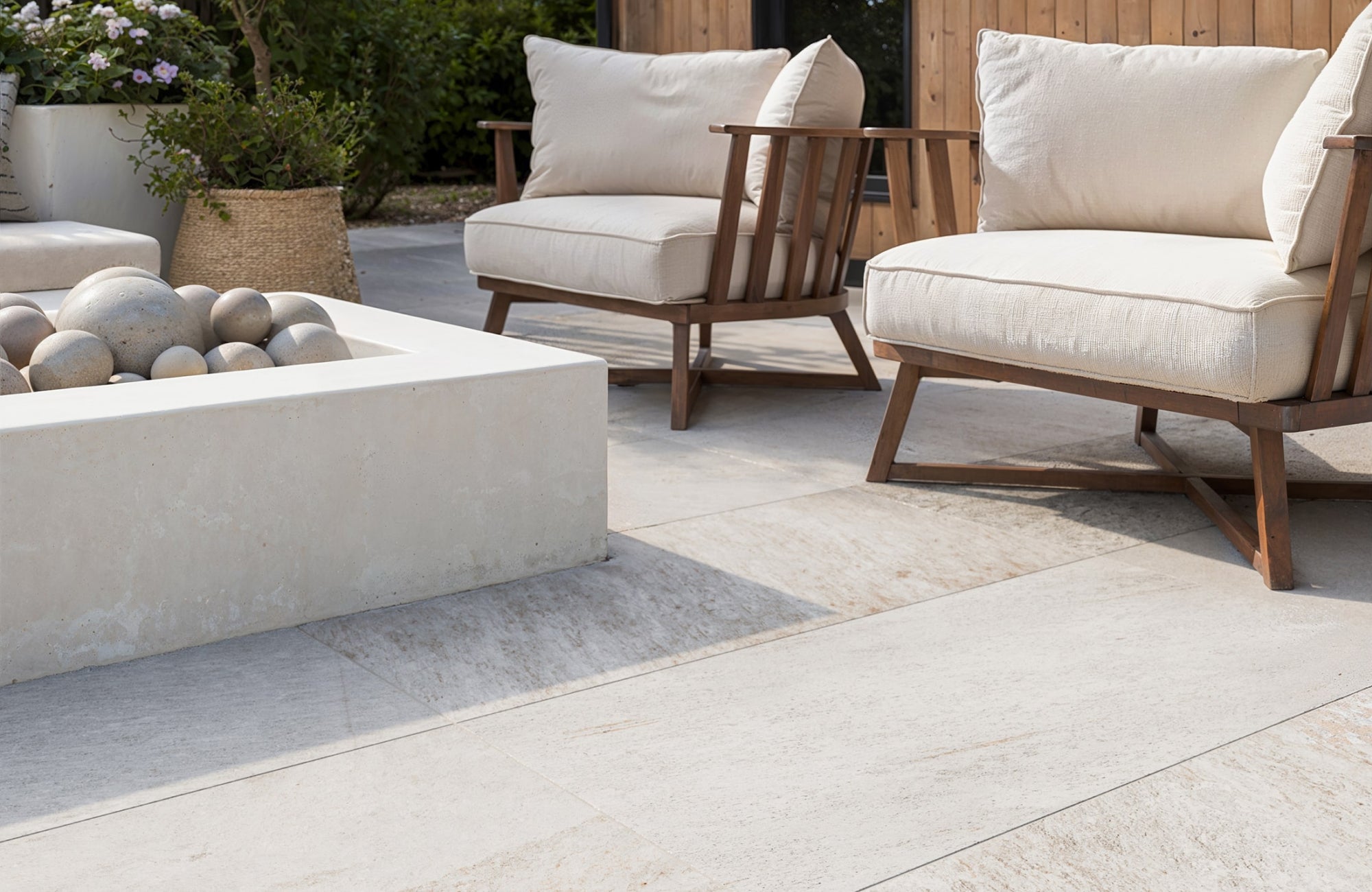 Outdoor seating area with large porcelain pavers surrounding a modern fire pit, showing clean edging and layout.
