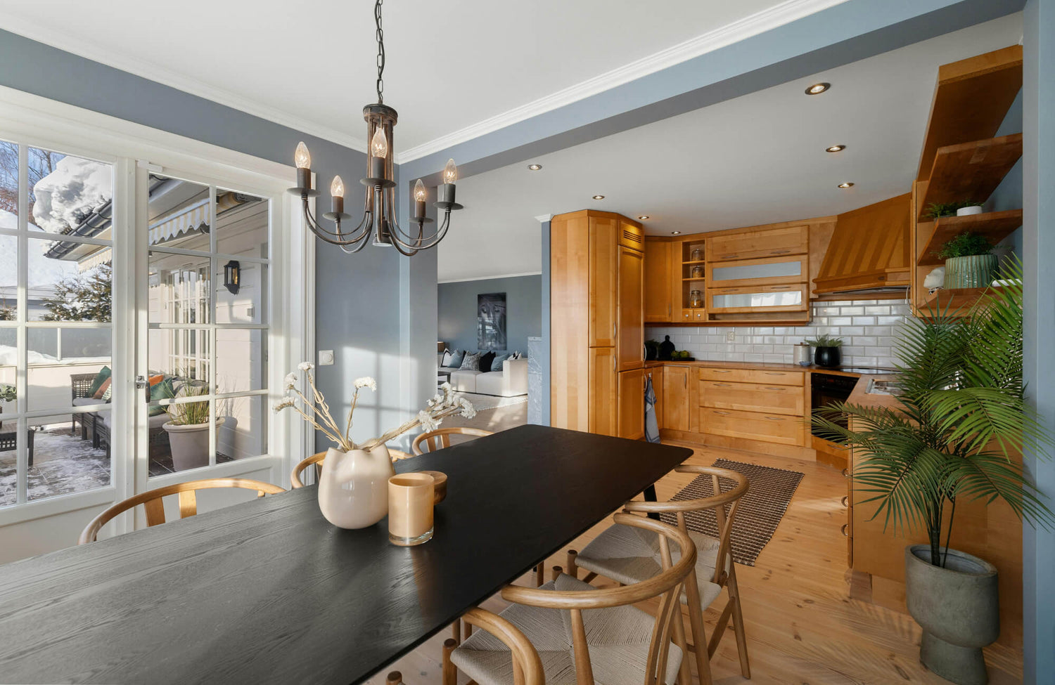 Modern dining area with black wood dining table and curved wooden chairs without cushions, highlighting clean lines and finishes.